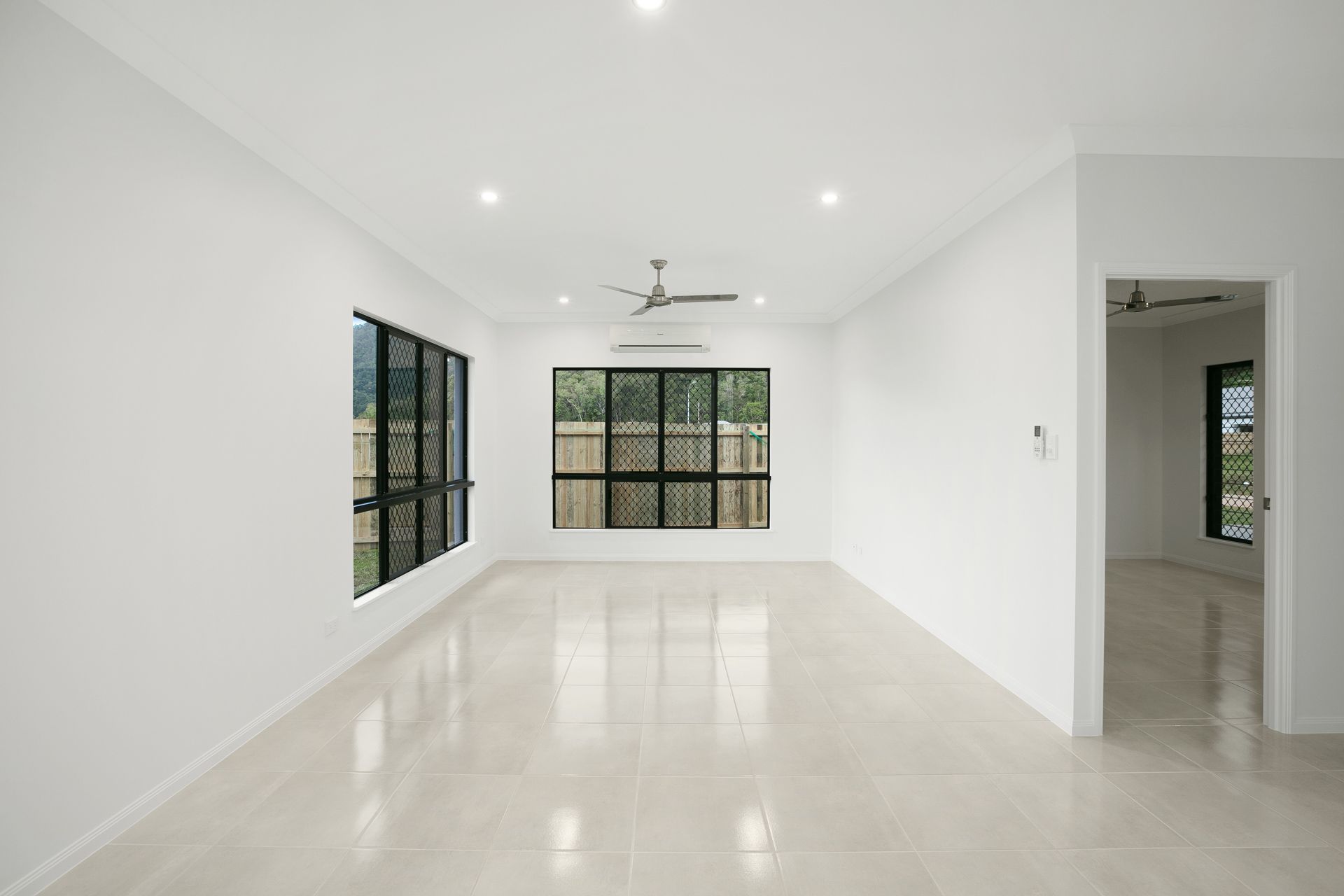 A Bright, Empty Living Room With White Walls — Ashlee Jones Homes in Gordonvale, QLD