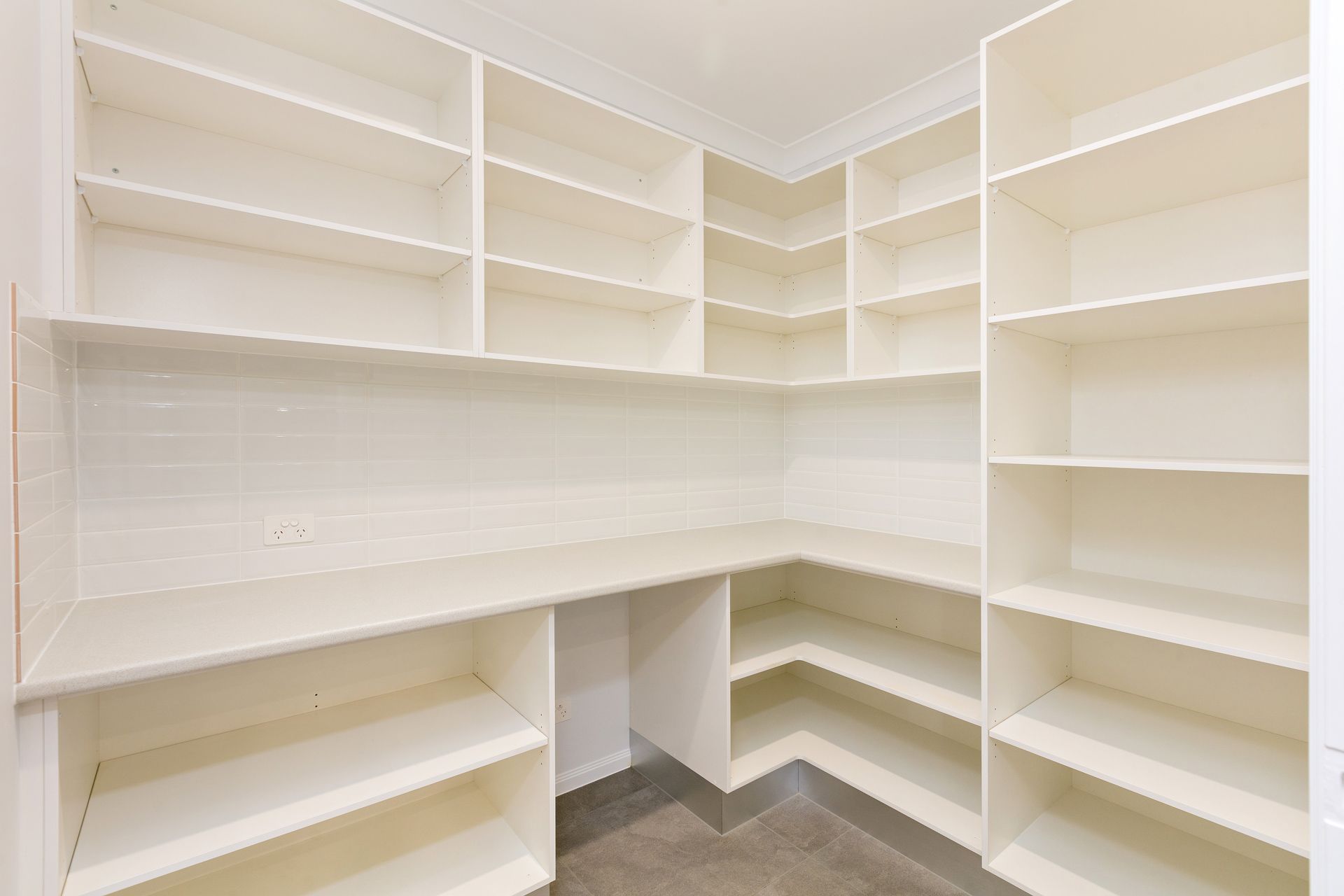 A Walk-in Pantry With White Shelves Lining the Walls — Ashlee Jones Homes in Gordonvale, QLD