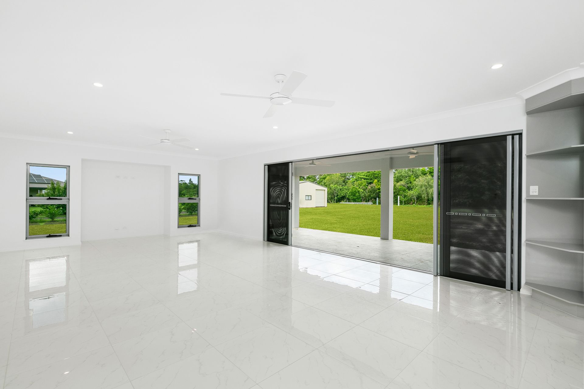 A Bright, Open-plan Living Room With White Tiled Floors — Ashlee Jones Homes in Gordonvale, QLD