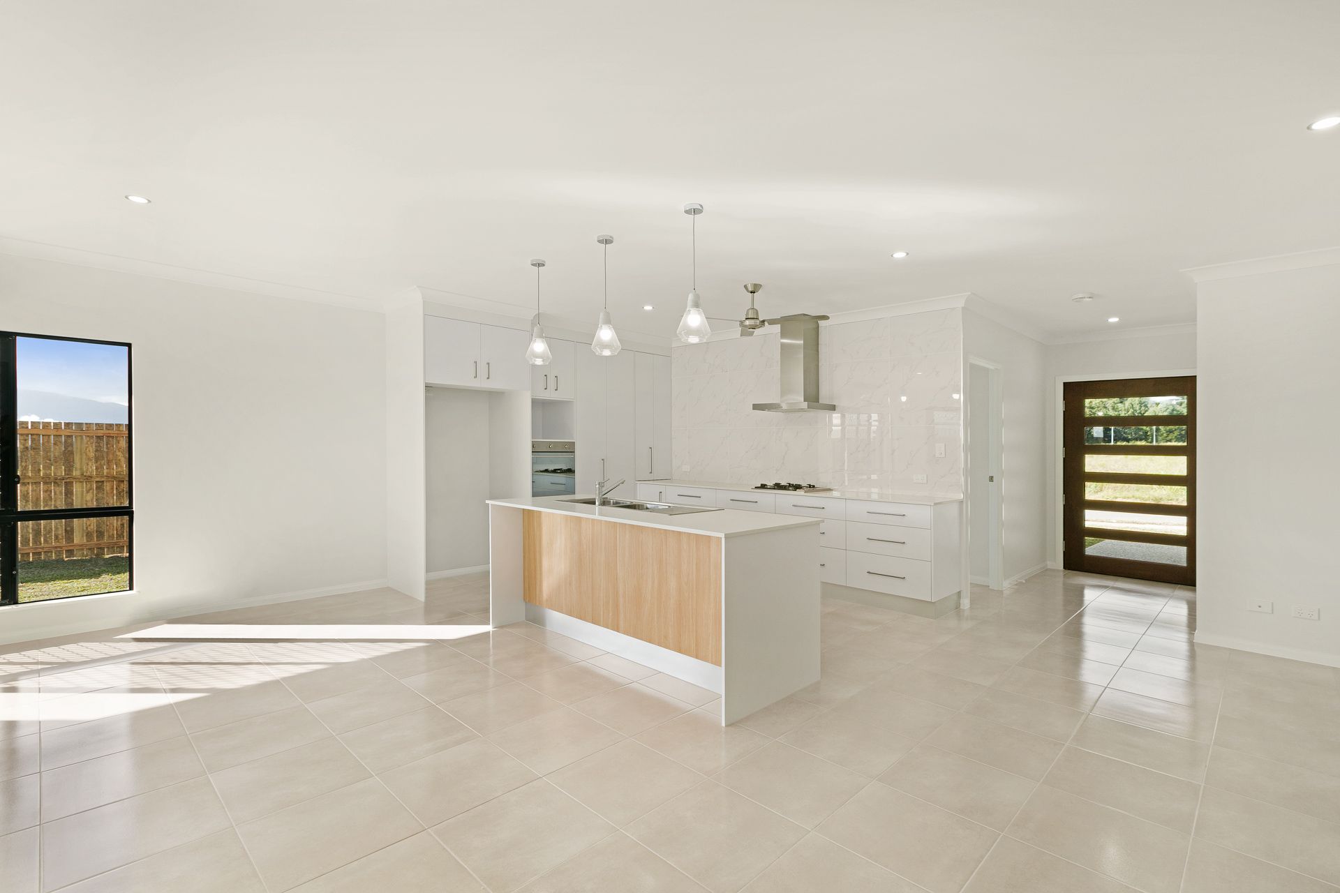 A Modern, Open-plan Kitchen With White Cabinetry — Ashlee Jones Homes in Gordonvale, QLD