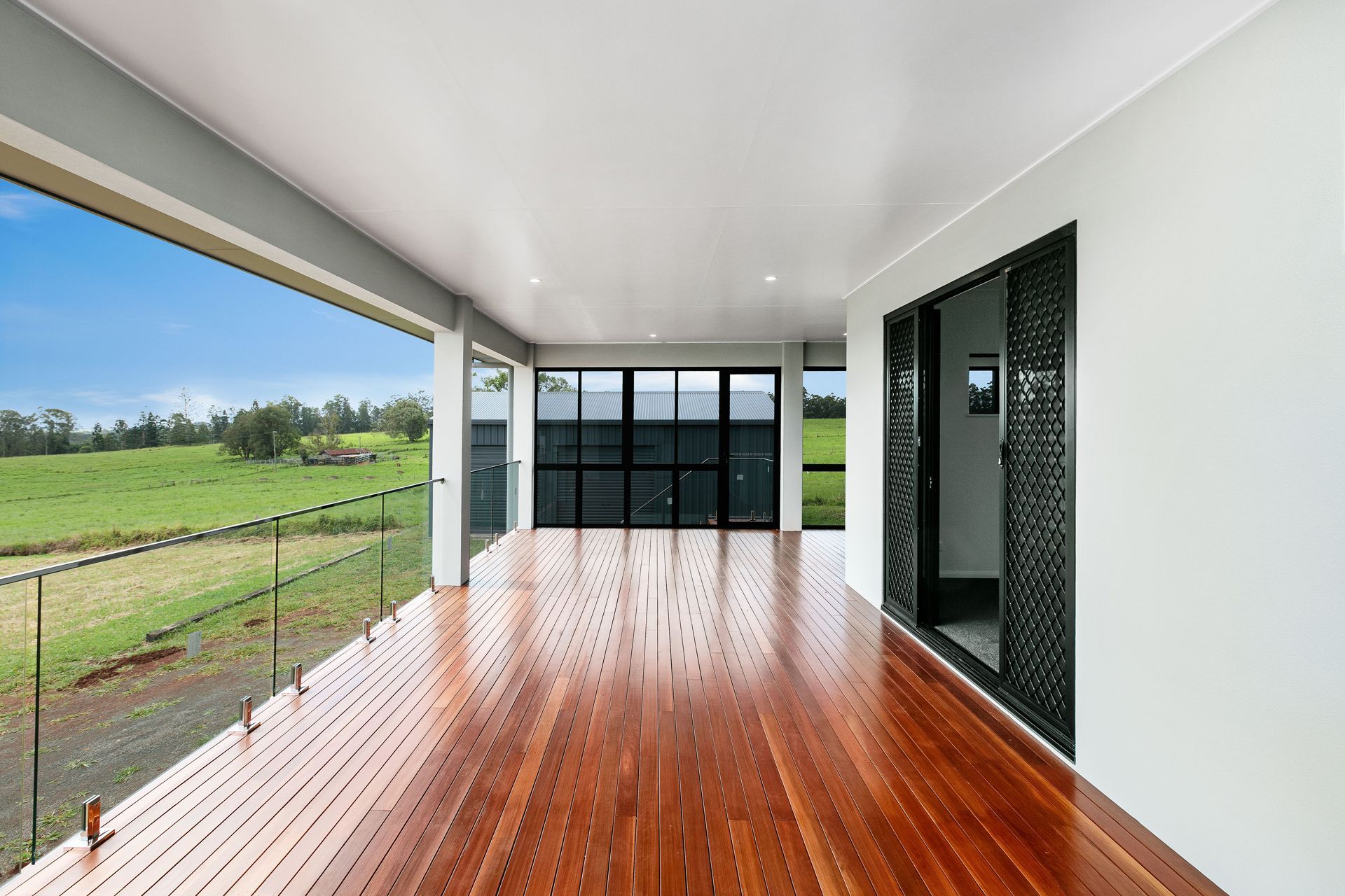 A Modern Covered Deck With Polished Wooden Floors — Ashlee Jones Homes in Gordonvale, QLD