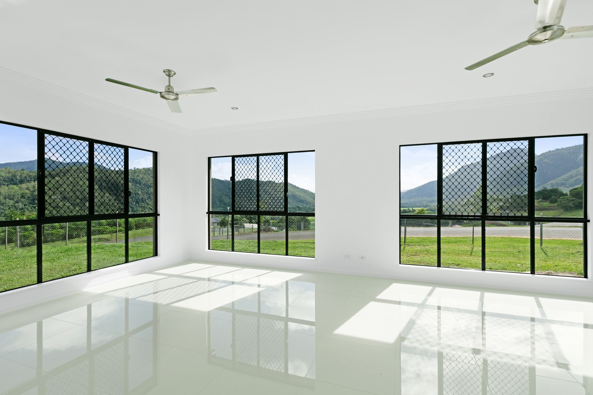 Empty, Sunlit Room With White Walls, Reflective Floor Tiles — Ashlee Jones Homes in Gordonvale, QLD