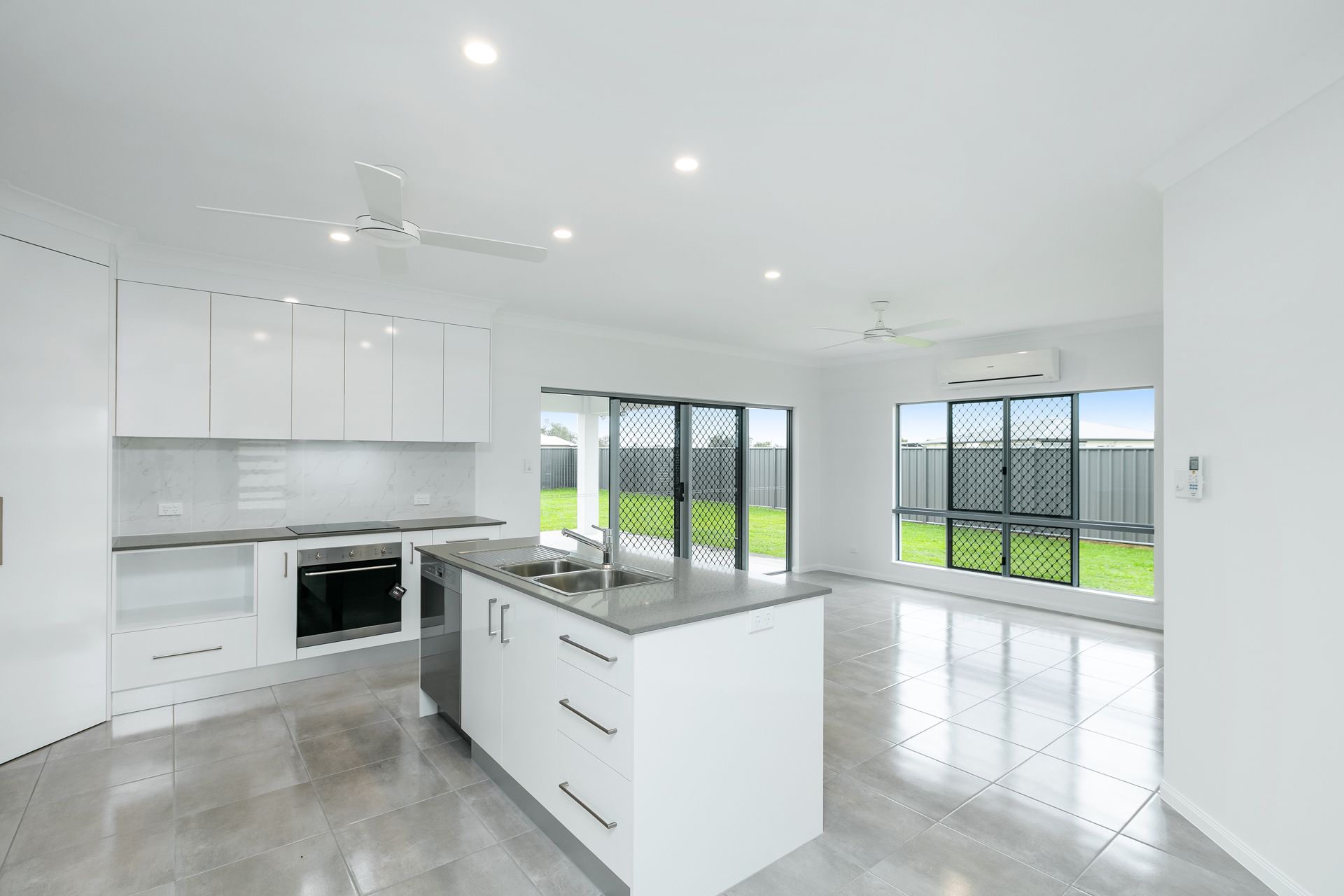 Modern Kitchen With White Cabinets, Stone Island Bench — Ashlee Jones Homes in Gordonvale, QLD