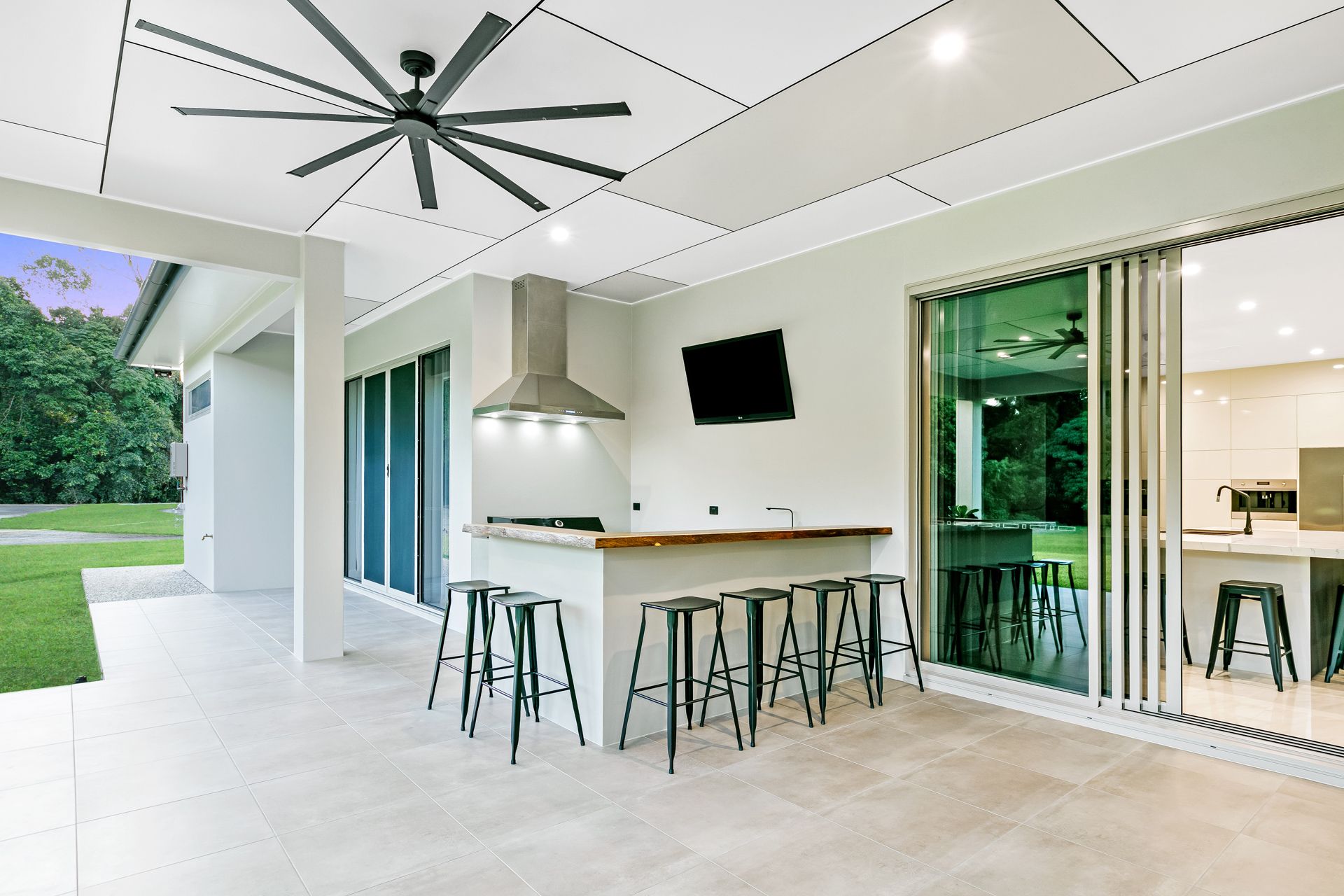 A Modern Outdoor Kitchen on a Tiled Patio, Featuring a Built-in Grill — Ashlee Jones Homes in Gordonvale, QLD