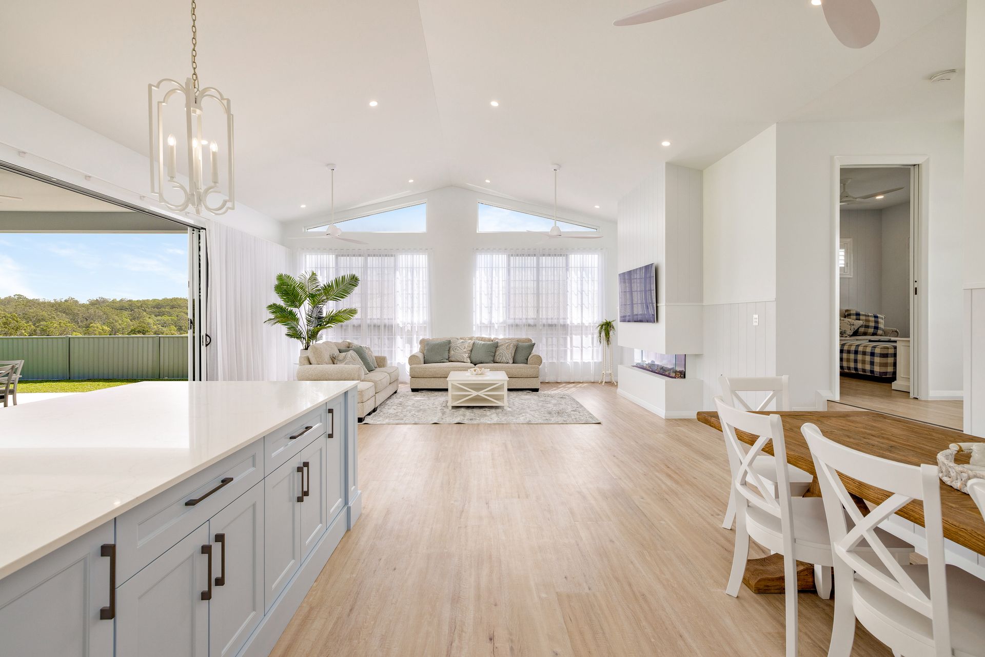 An Empty Kitchen With A Large Island And Sliding Glass Doors Leading To A Patio — Ashlee Jones Homes in Gordonvale, QLD