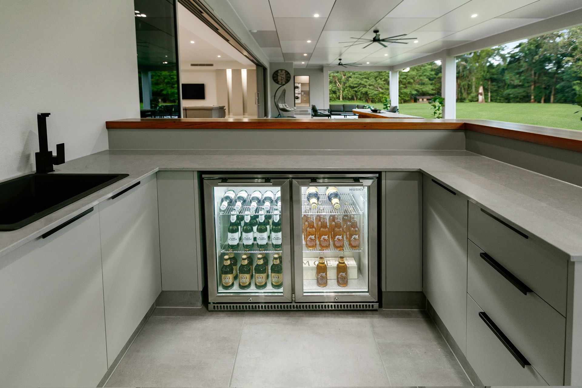 An Outdoor Kitchen With Light Gray Cabinets — Ashlee Jones Homes in Gordonvale, QLD