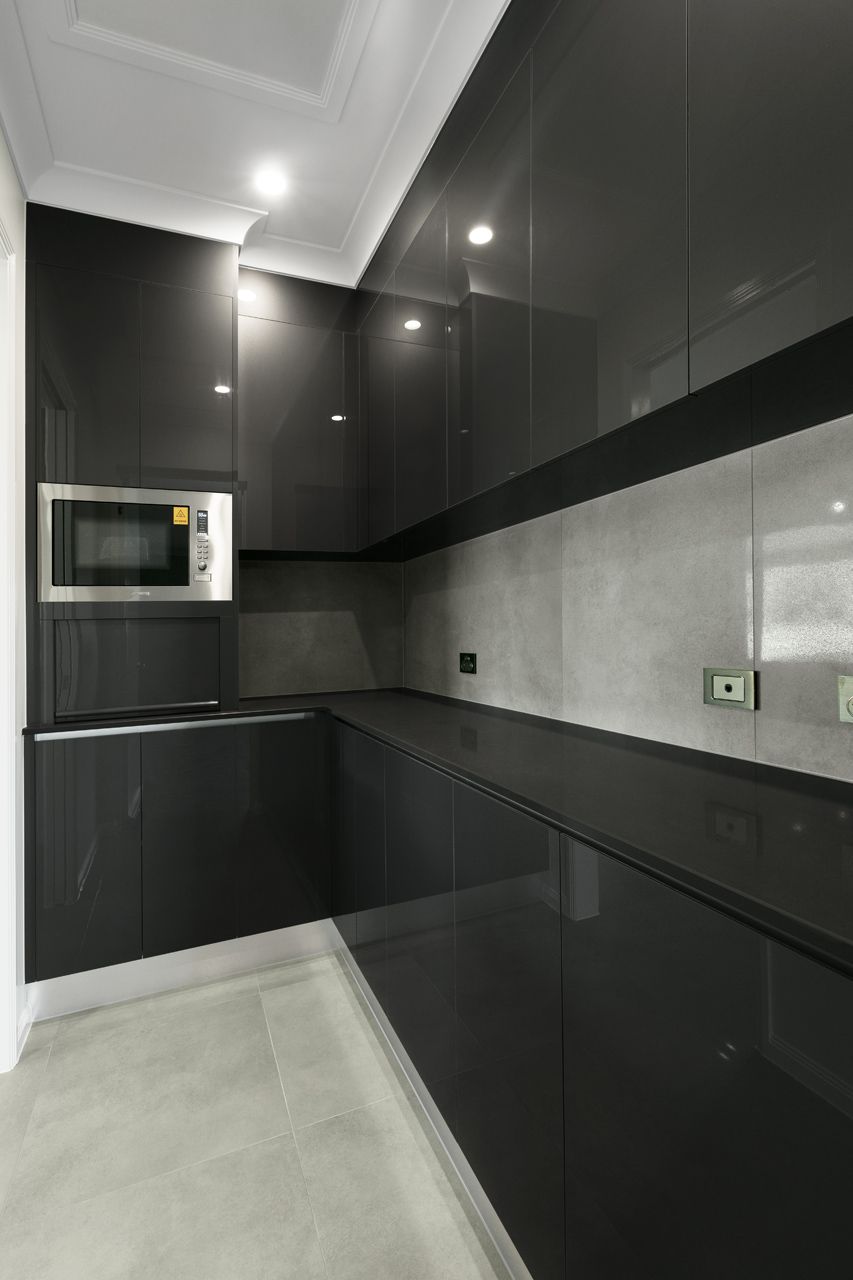 A Modern L-shaped Kitchen Featuring Glossy Dark Grey Cabinetry — Ashlee Jones Homes in Gordonvale, QLD