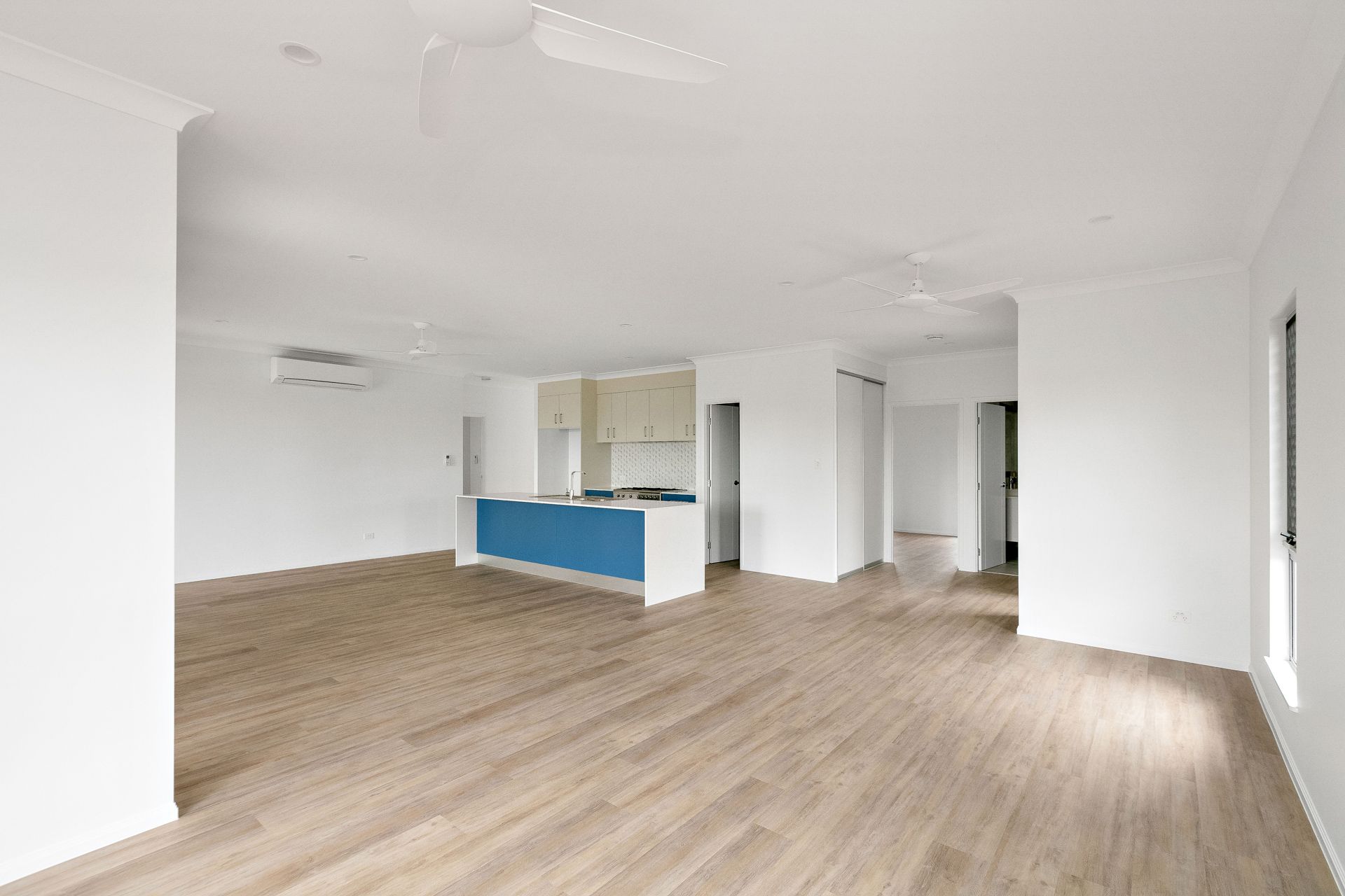 An Open-plan Interior With Light Wood Flooring, White Walls — Ashlee Jones Homes in Gordonvale, QLD