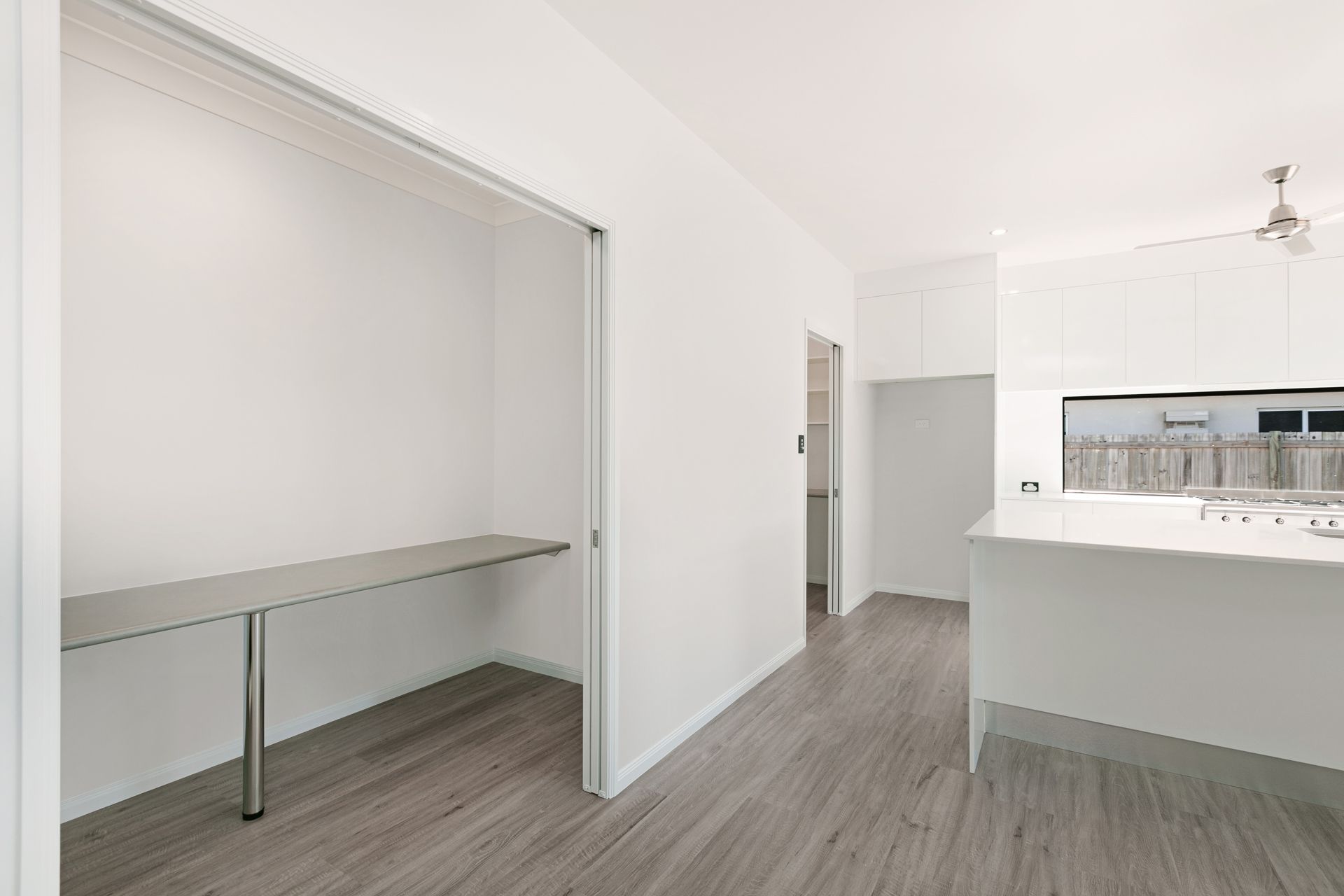 A Bright, Minimalist Room Featuring a Nook With a Floating Desk — Ashlee Jones Homes in Gordonvale, QLD
