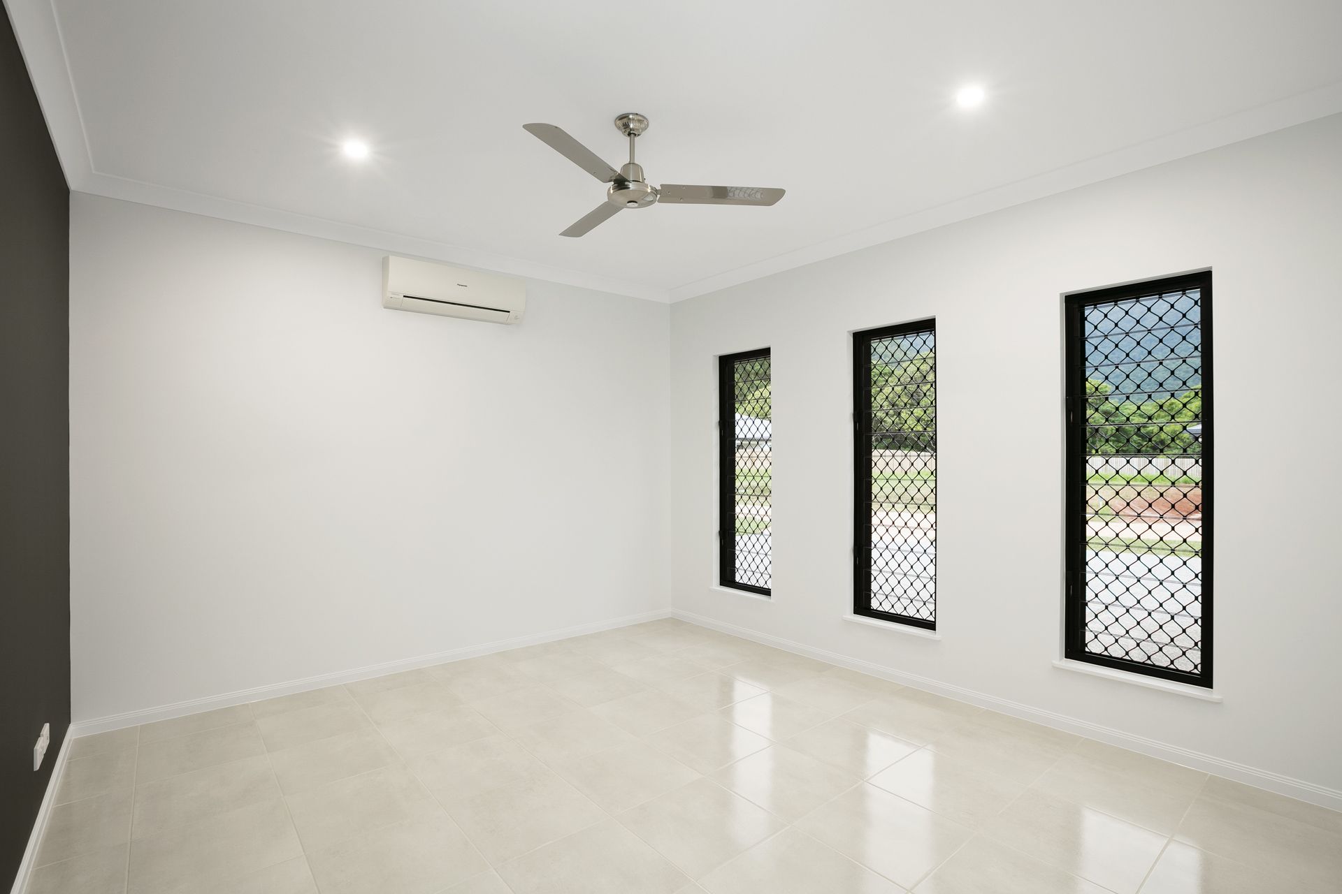 A Bright, Empty Room With White Walls, Tiled Floors — Ashlee Jones Homes in Gordonvale, QLD