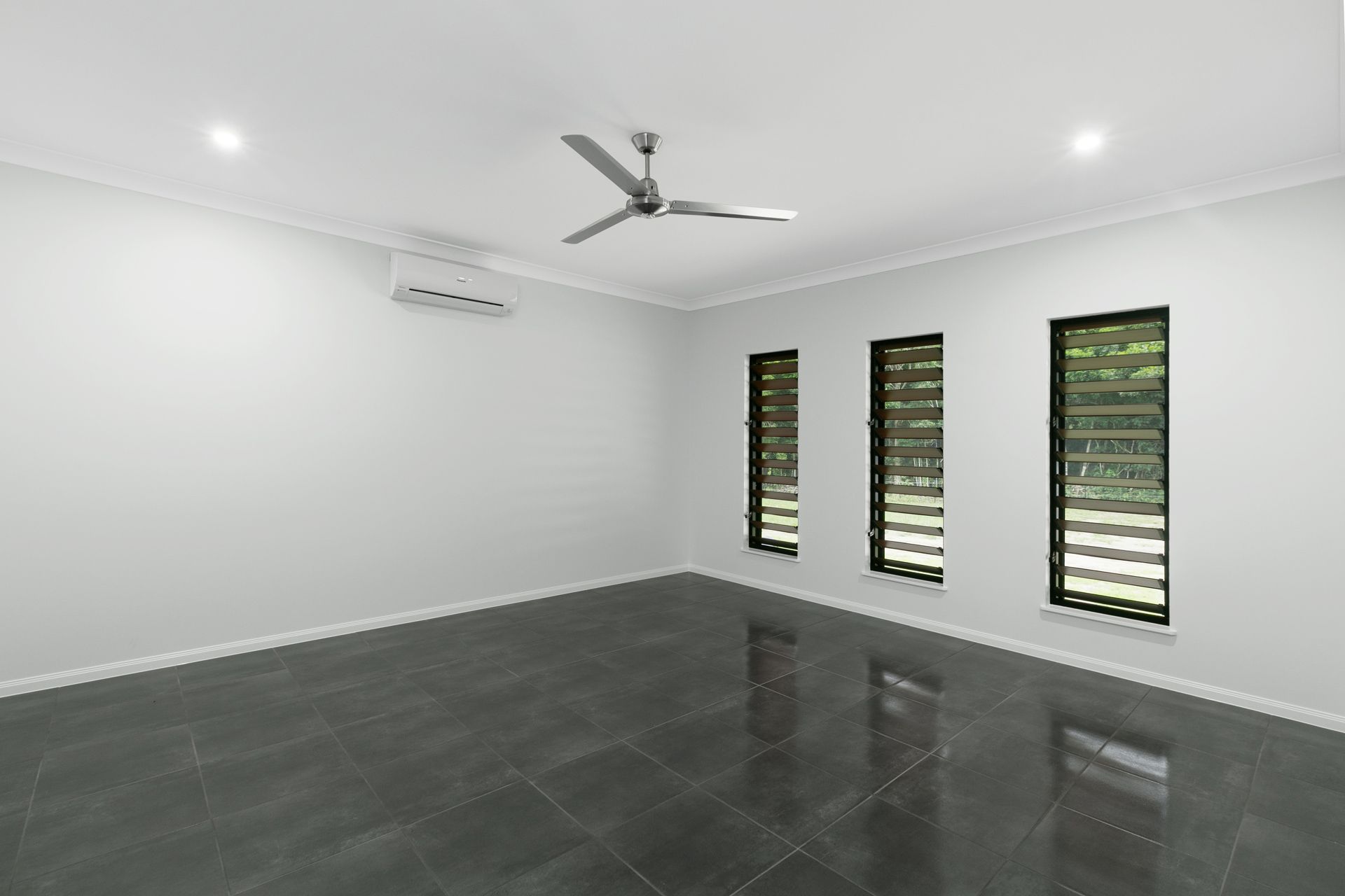 An Empty Room With White Walls, Dark Grey Tile Flooring — Ashlee Jones Homes in Gordonvale, QLD