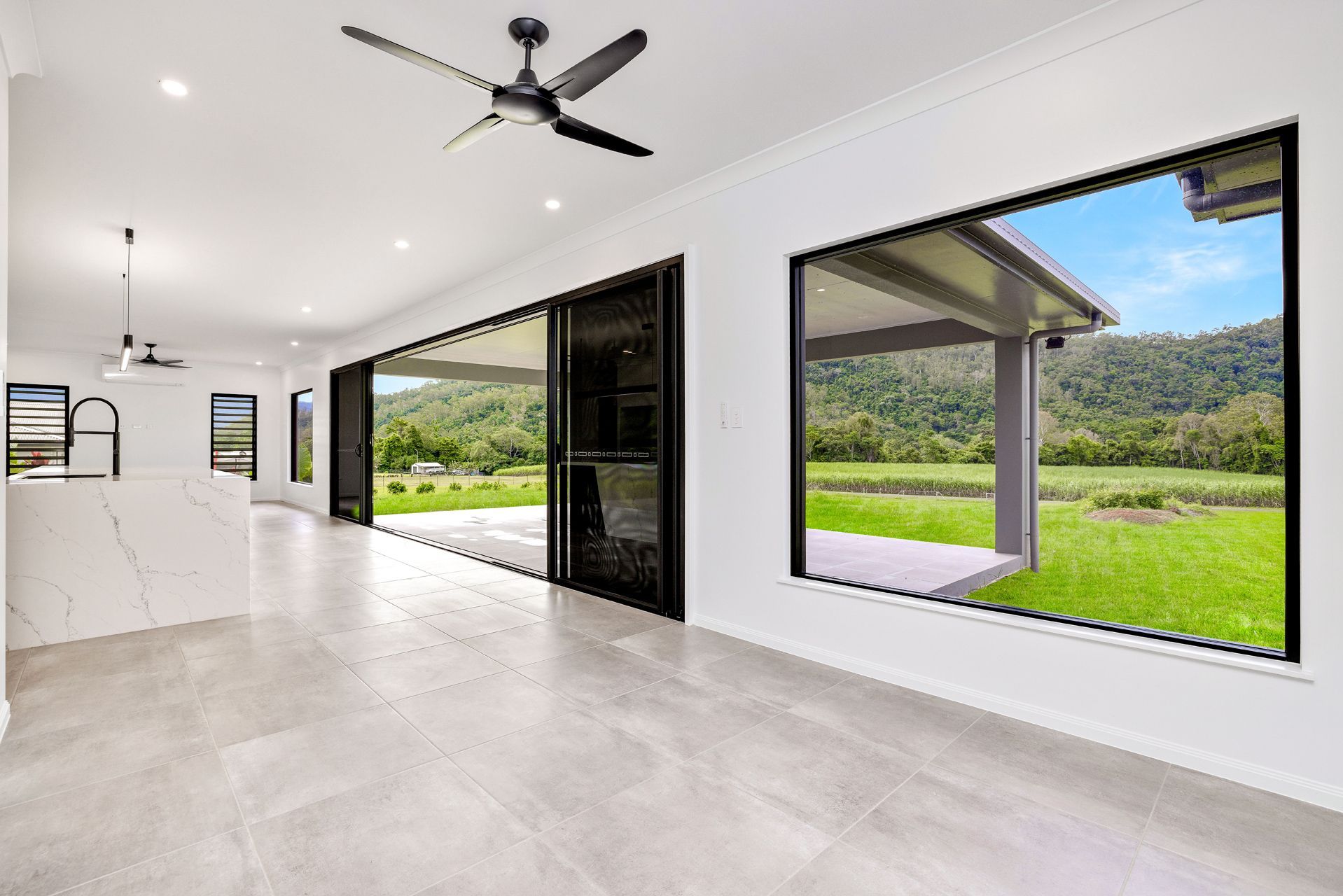 A Bright, Modern Indoor Space With Light Tile Floors — Ashlee Jones Homes in Gordonvale, QLD