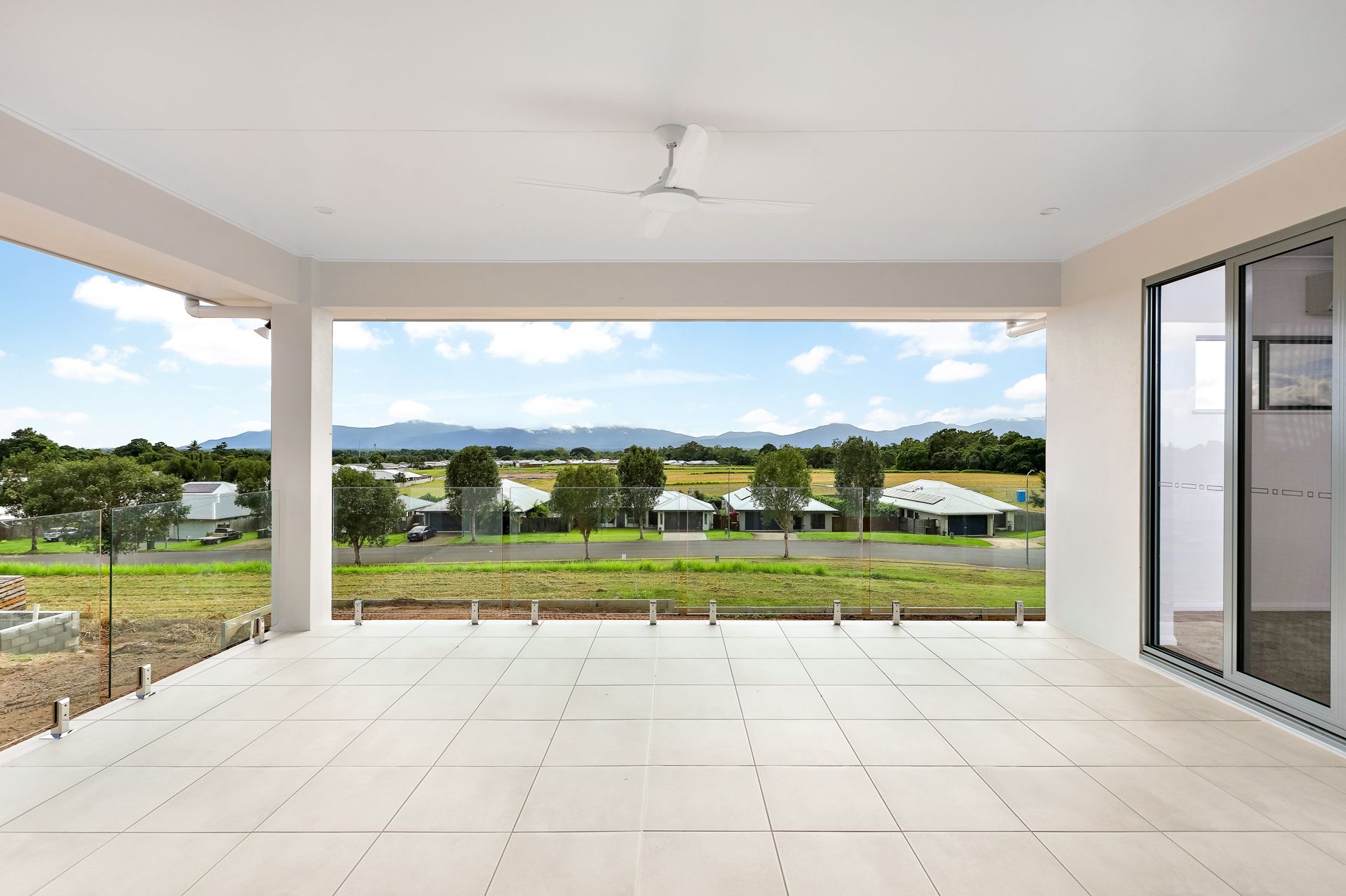 Modern Covered Patio With Light Tiles, a Ceiling Fan — Ashlee Jones Homes in Gordonvale, QLD