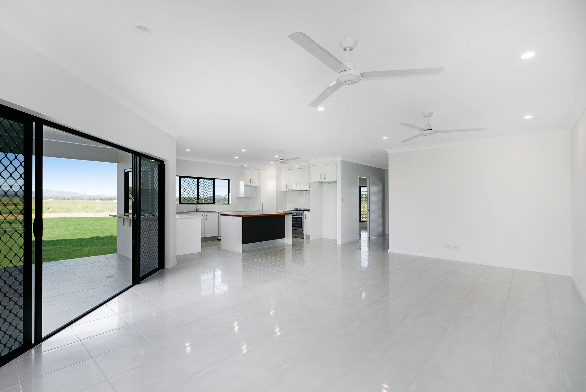 An Open-plan Living Room With White Tiled Floors — Ashlee Jones Homes in Gordonvale, QLD