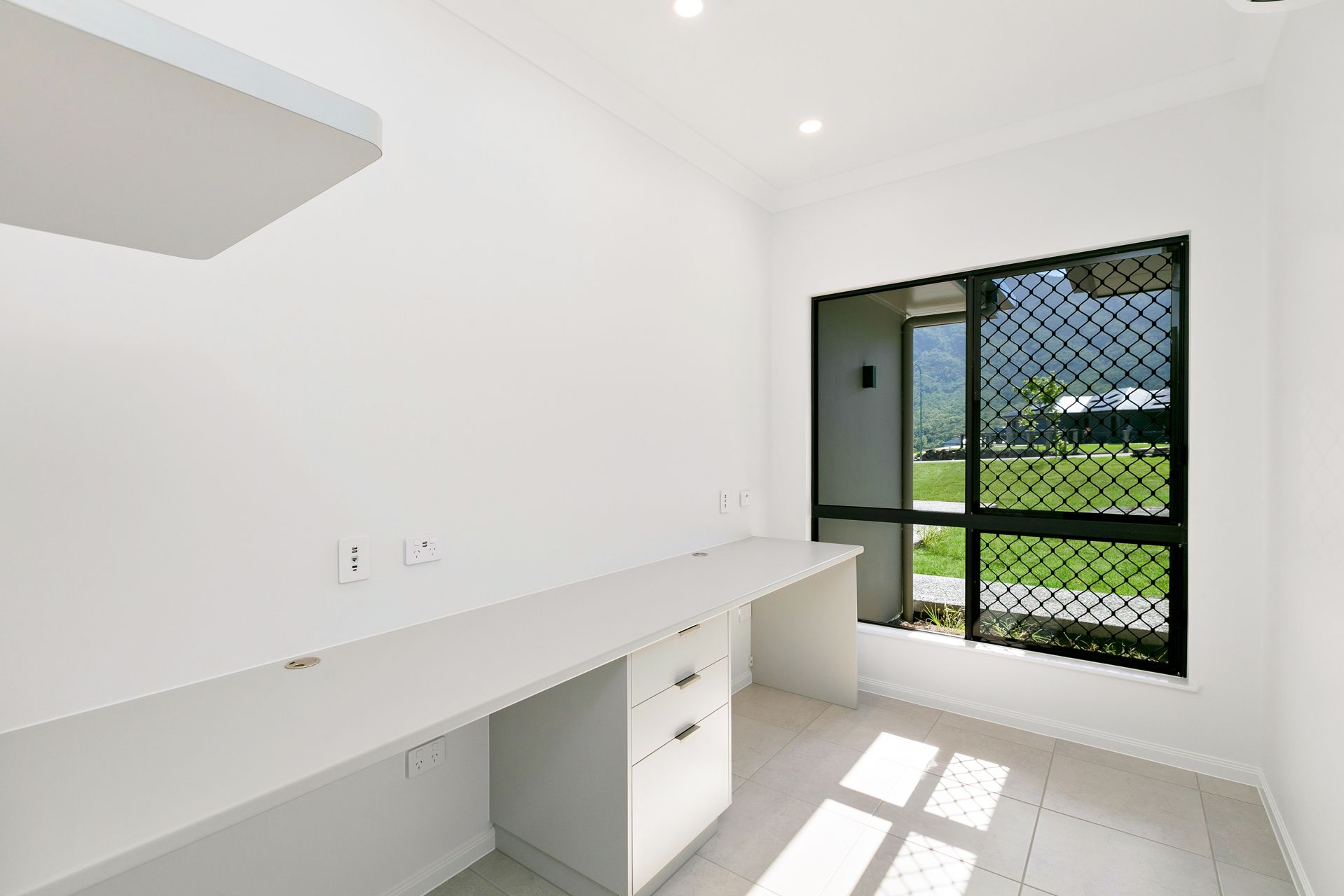 A Brightly Lit Home Office Featuring a Long White Desk — Ashlee Jones Homes in Gordonvale, QLD