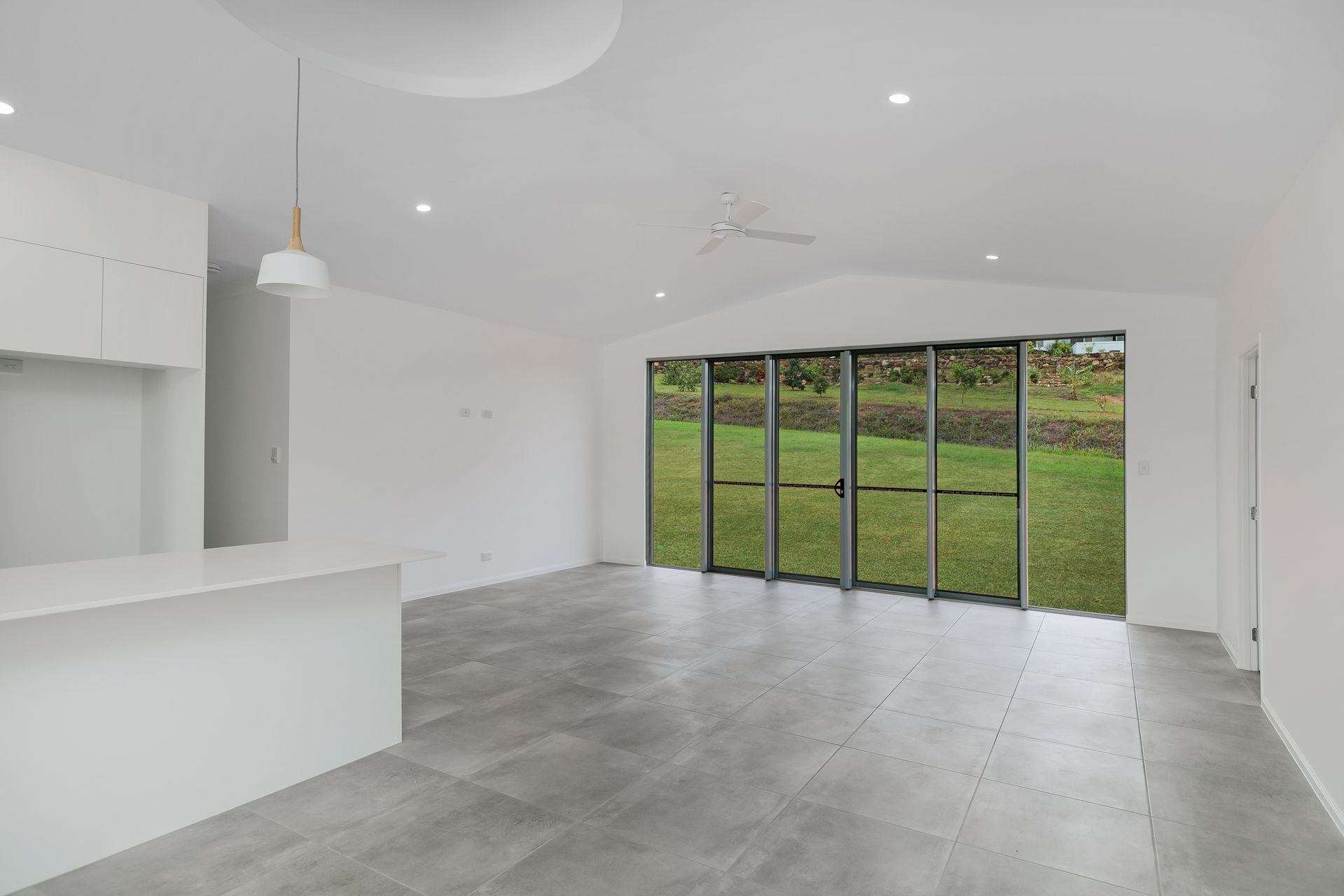 Modern, Minimalist Open-plan Living Room With Grey Tiled Floors — Ashlee Jones Homes in Gordonvale, QLD