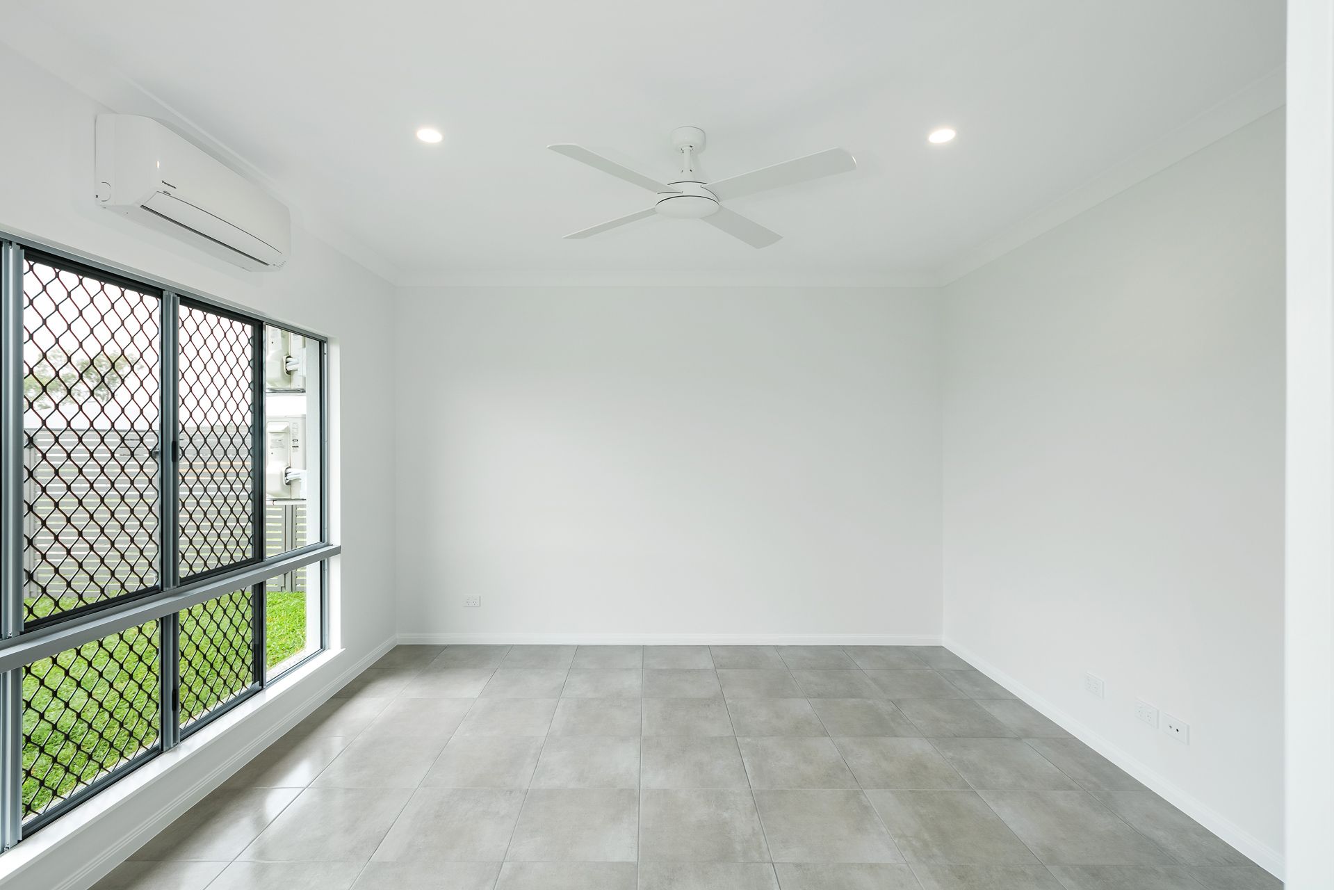 A Modern, Minimalist Room With White Walls, Grey Tiled Flooring — Ashlee Jones Homes in Gordonvale, QLD
