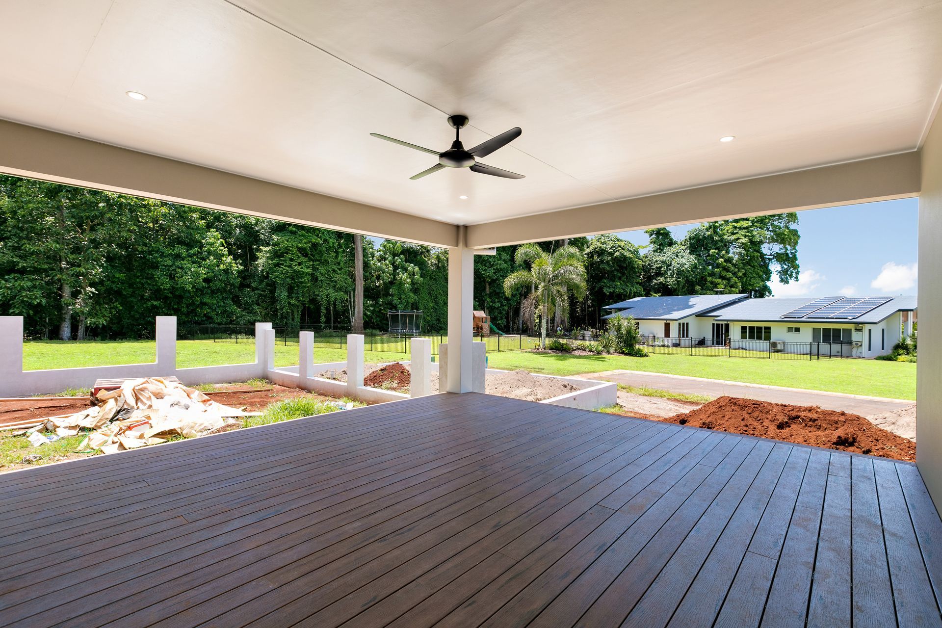 A Wide, Covered Deck With Dark Wood Flooring — Ashlee Jones Homes in Gordonvale, QLD