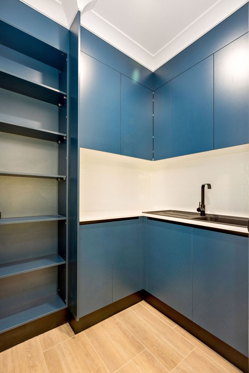 A Corner Kitchen or Pantry With Deep Blue Cabinets — Ashlee Jones Homes in Gordonvale, QLD
