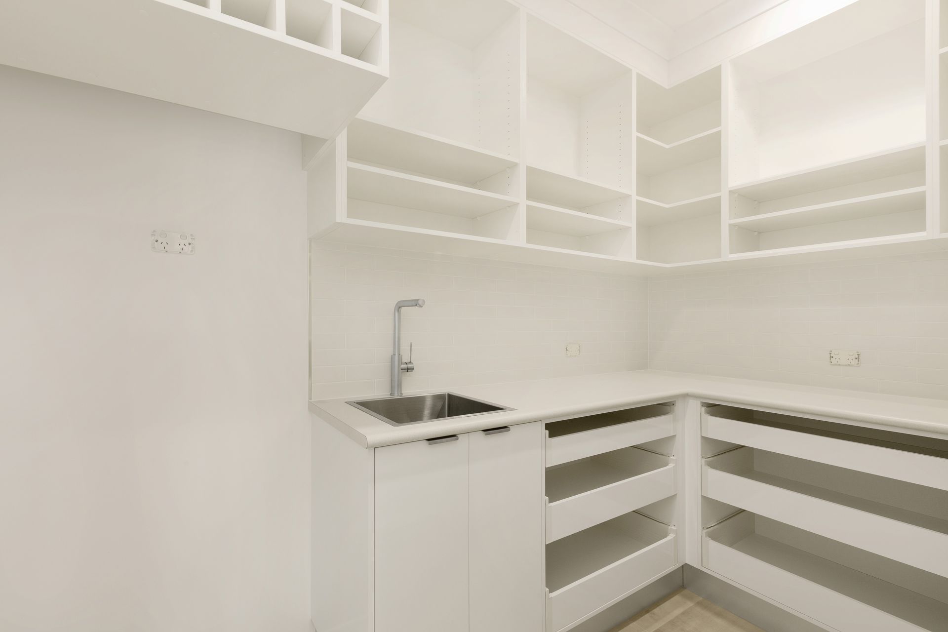 A Modern, Minimalist Pantry With White Cabinets — Ashlee Jones Homes in Gordonvale, QLD
