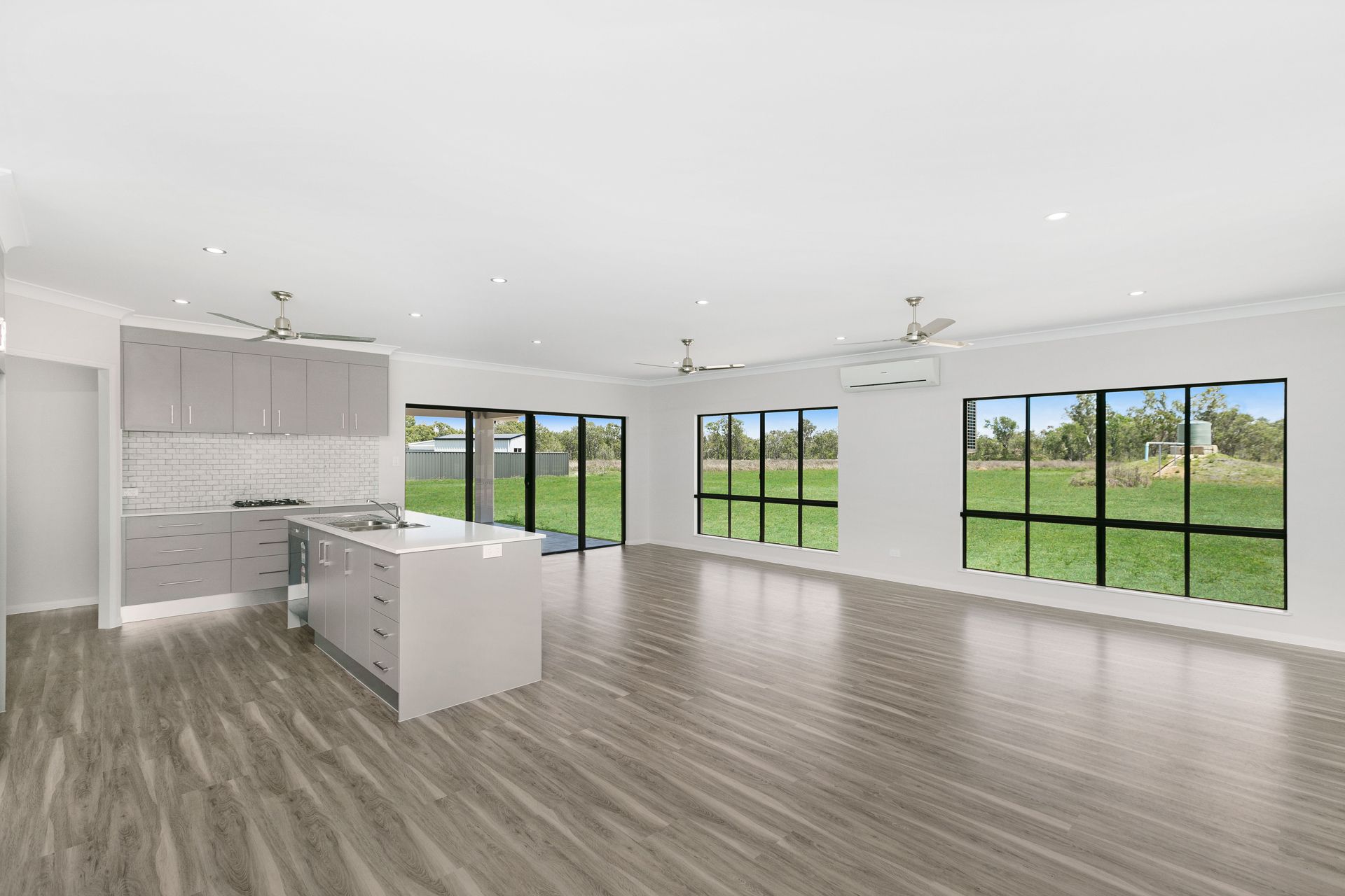 Modern Open-plan Kitchen and Living Area With Light Wood Floors — Ashlee Jones Homes in Gordonvale, QLD