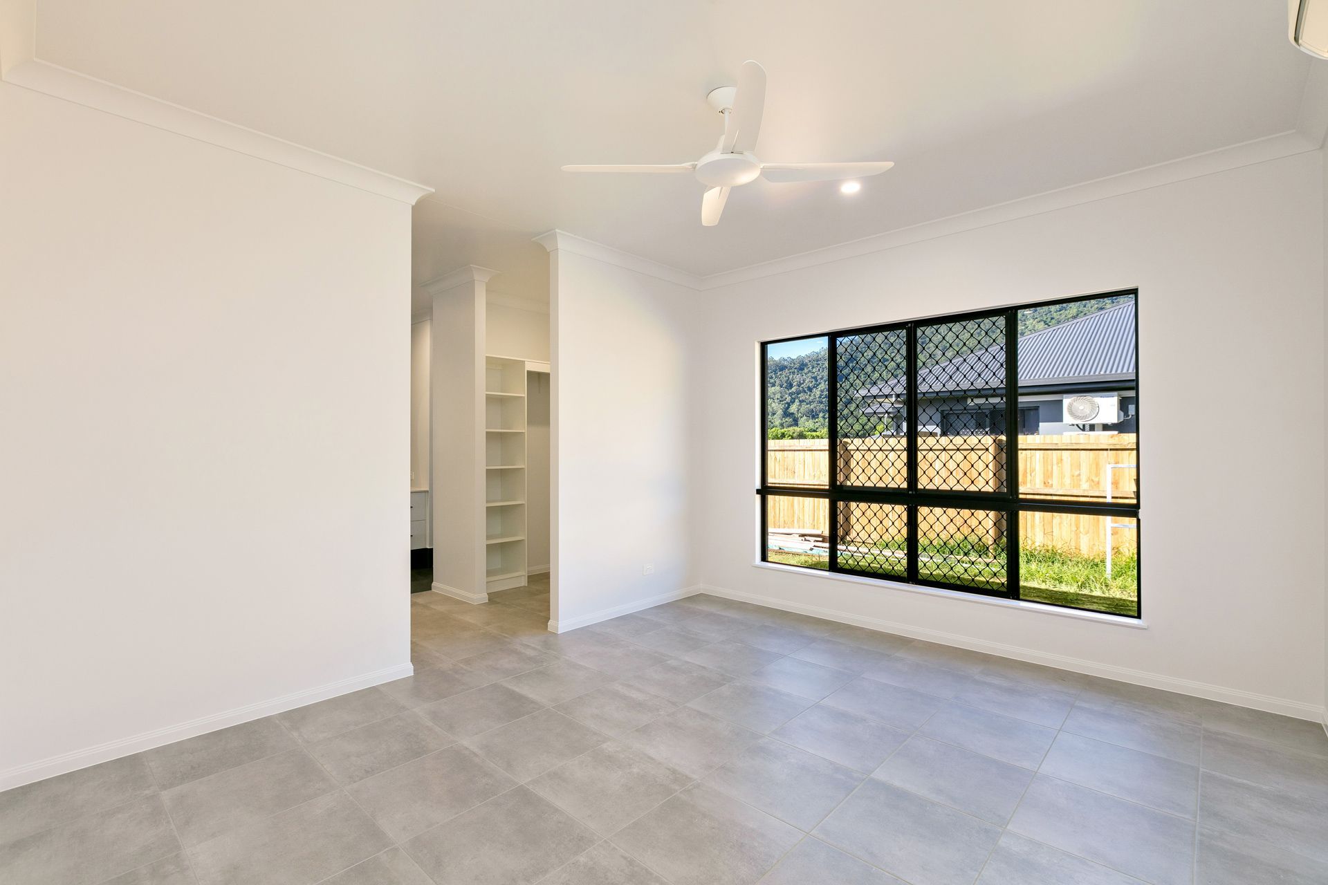 An Empty Room With White Walls, Light Gray Tile Floors — Ashlee Jones Homes in Gordonvale, QLD