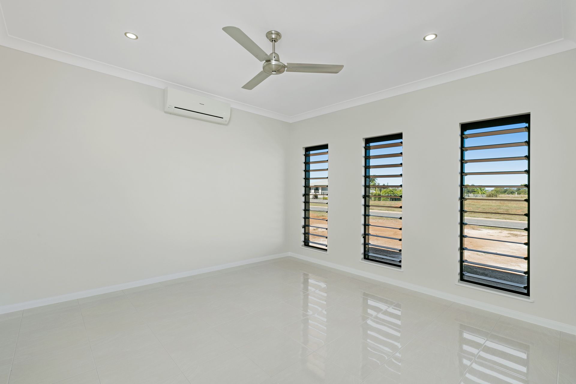 A Bright, Empty Room With White Walls, Tiled Floors — Ashlee Jones Homes in Gordonvale, QLD