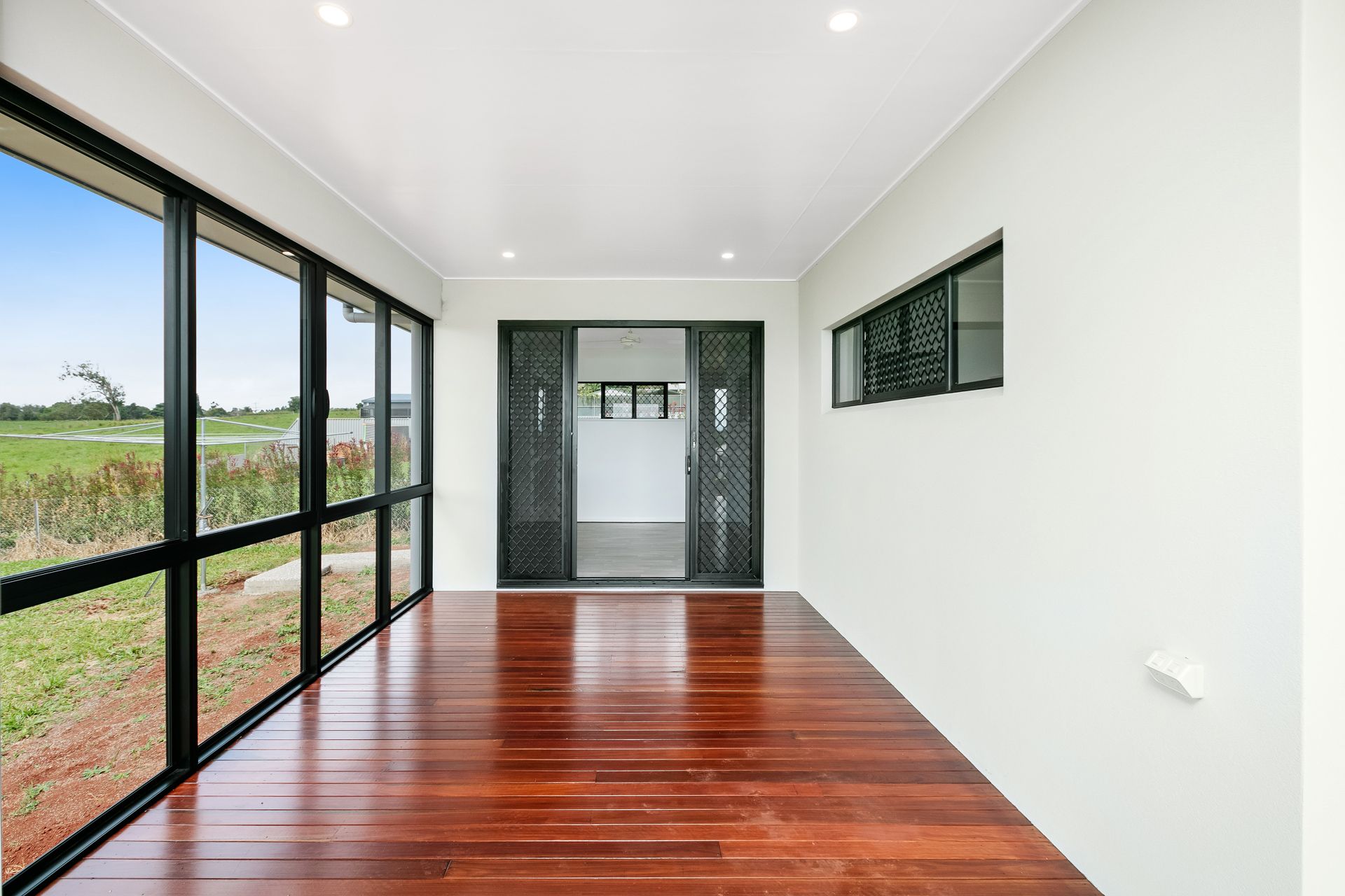 A Covered Patio With a Polished Wood Floor — Ashlee Jones Homes in Gordonvale, QLD