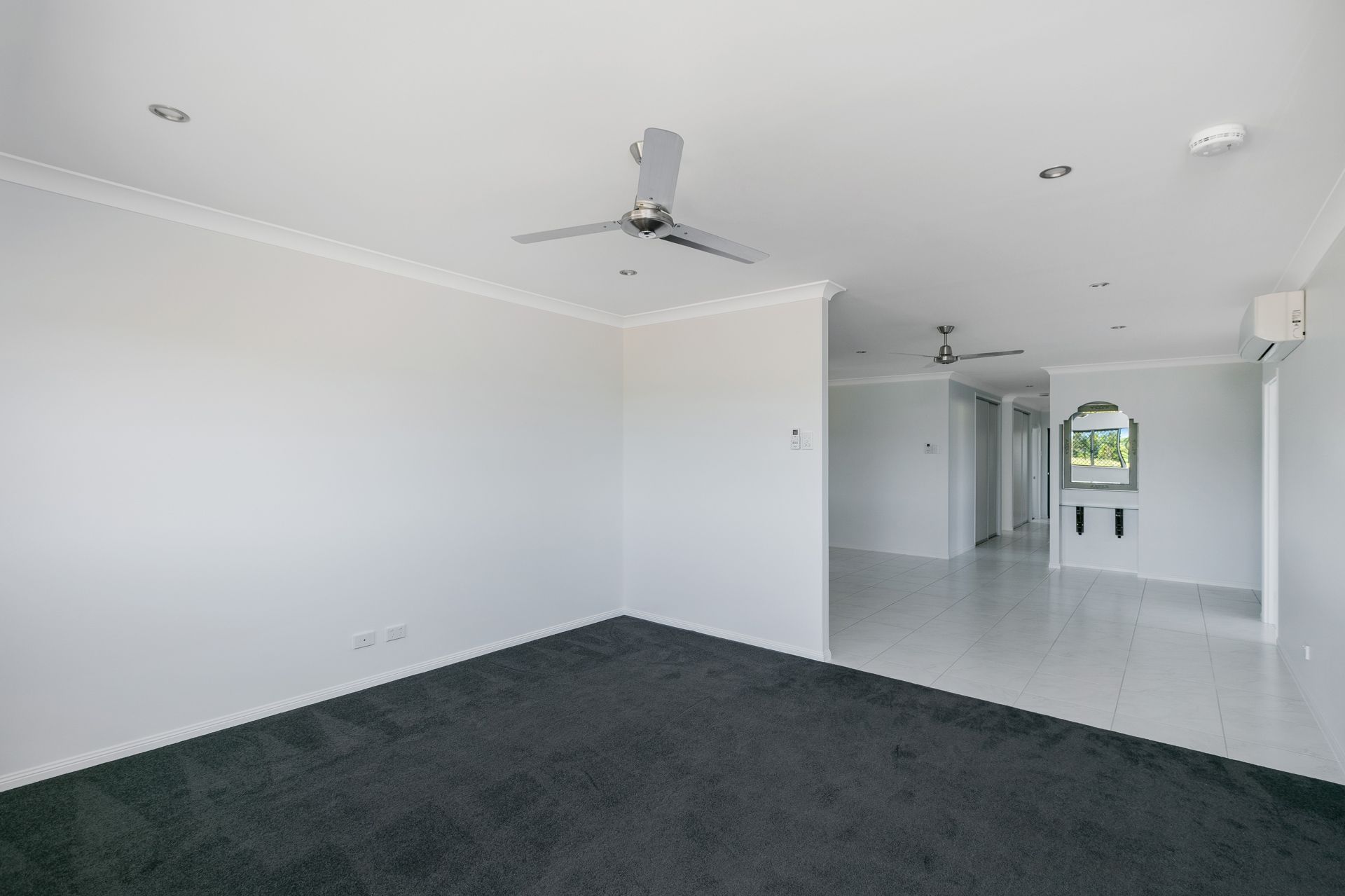 An Interior View of a Room With Dark Grey Carpet and White Walls — Ashlee Jones Homes in Gordonvale, QLD