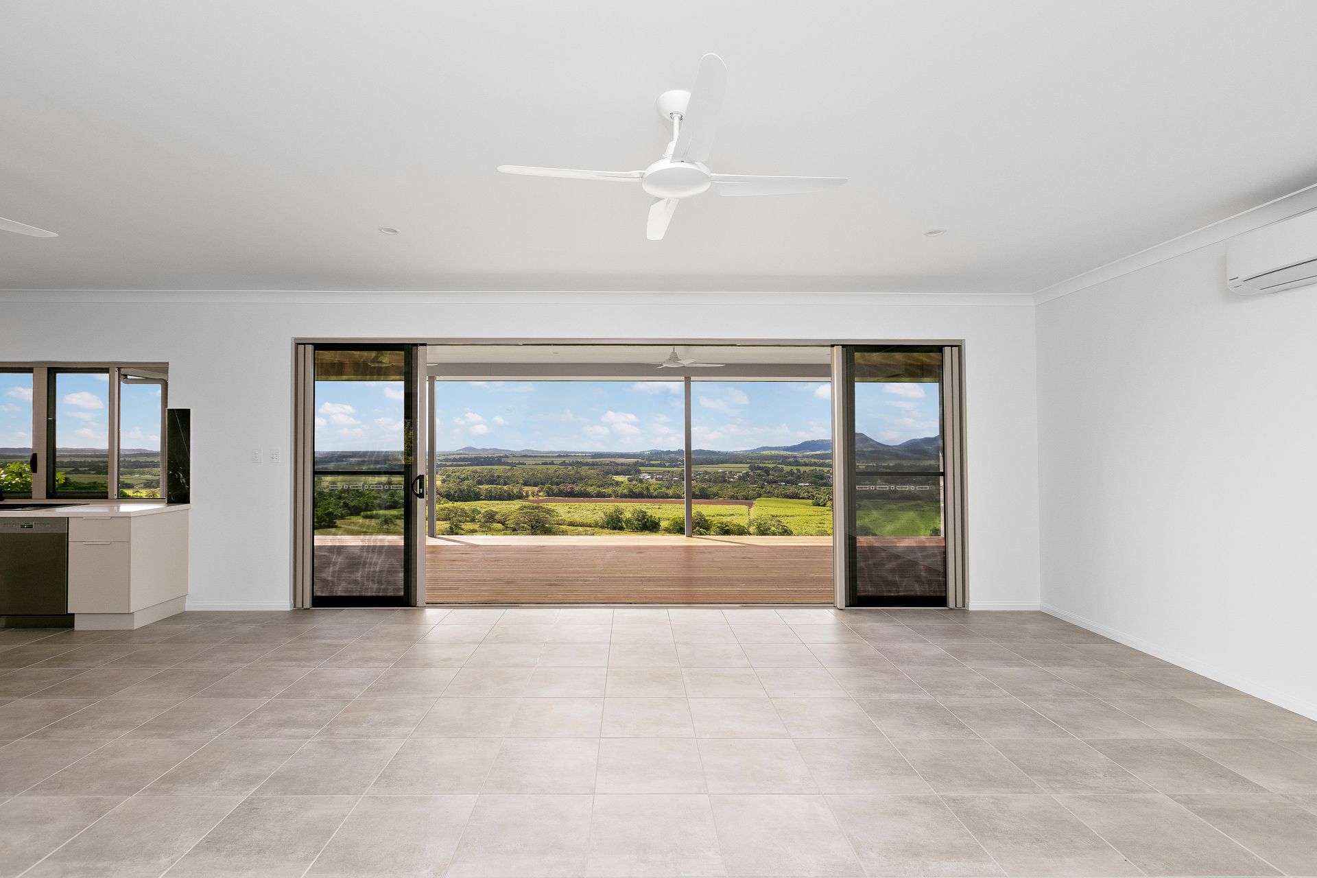 A Bright, Open-plan Living Room With Grey Tile Floors — Ashlee Jones Homes in Gordonvale, QLD
