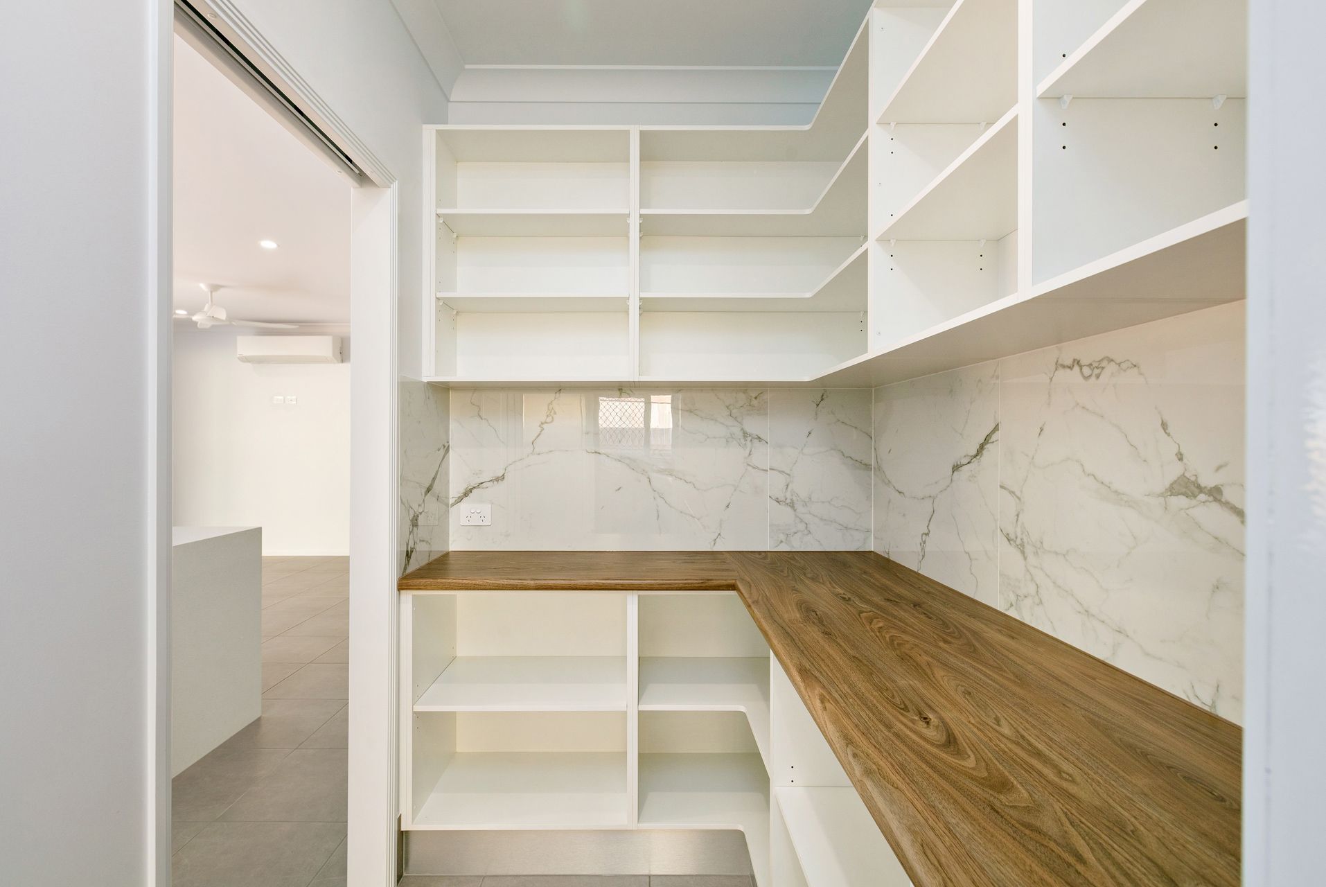 A Modern Walk-in Pantry With White Shelves — Ashlee Jones Homes in Gordonvale, QLD