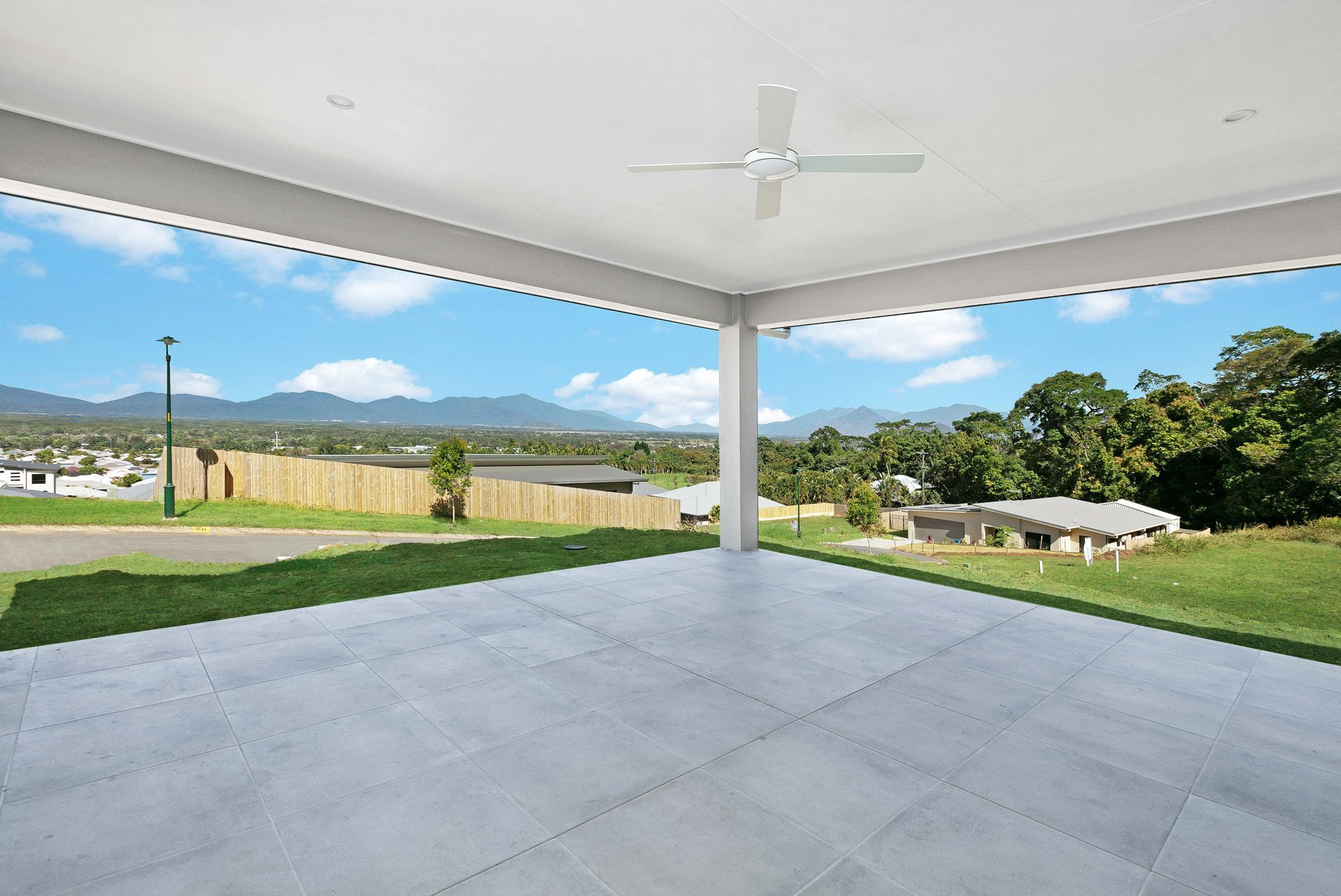A Covered Outdoor Patio With Light Gray Stone Tiles — Ashlee Jones Homes in Gordonvale, QLD