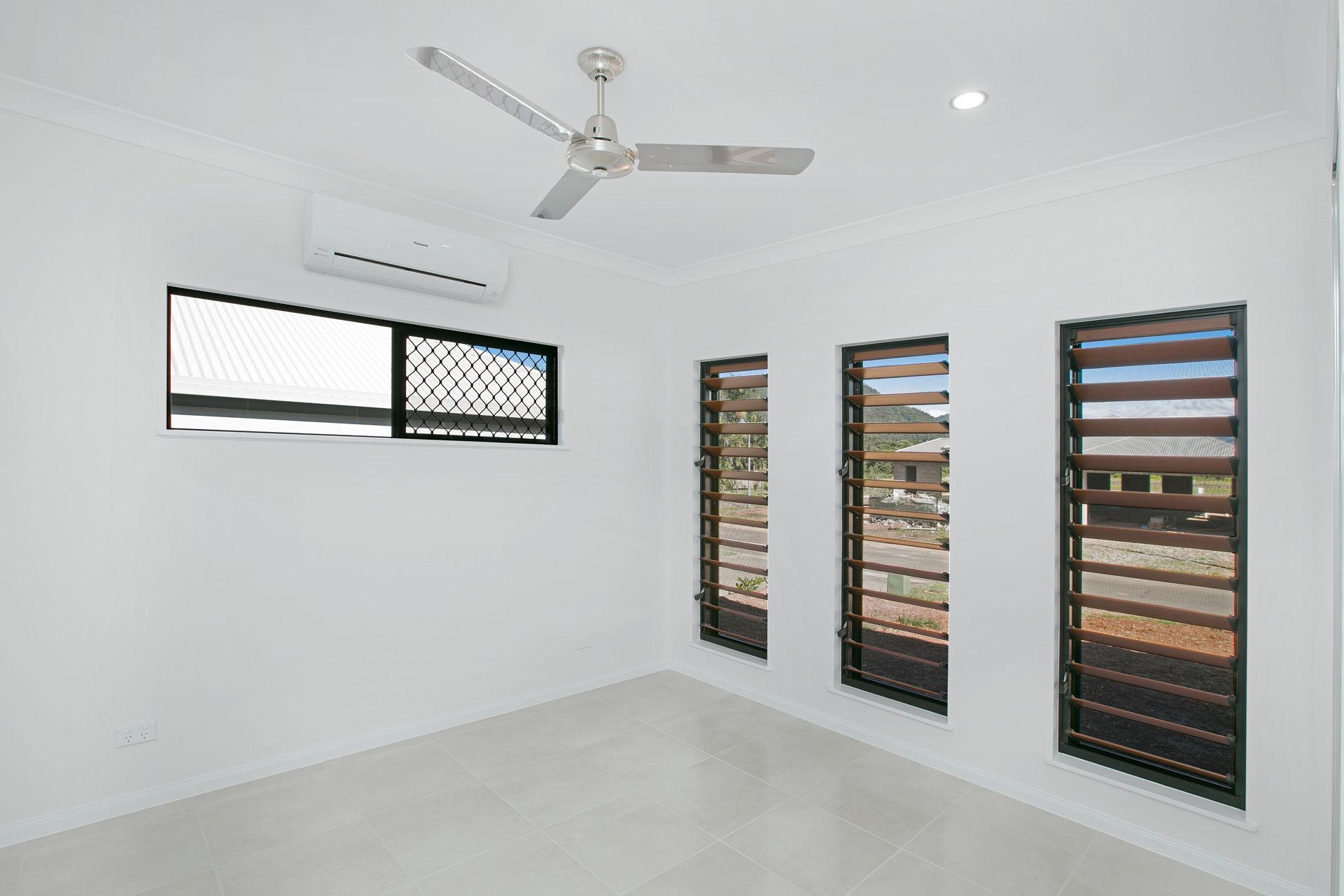 A Bright, Empty Room With White Walls, Light Tile Floors — Ashlee Jones Homes in Gordonvale, QLD