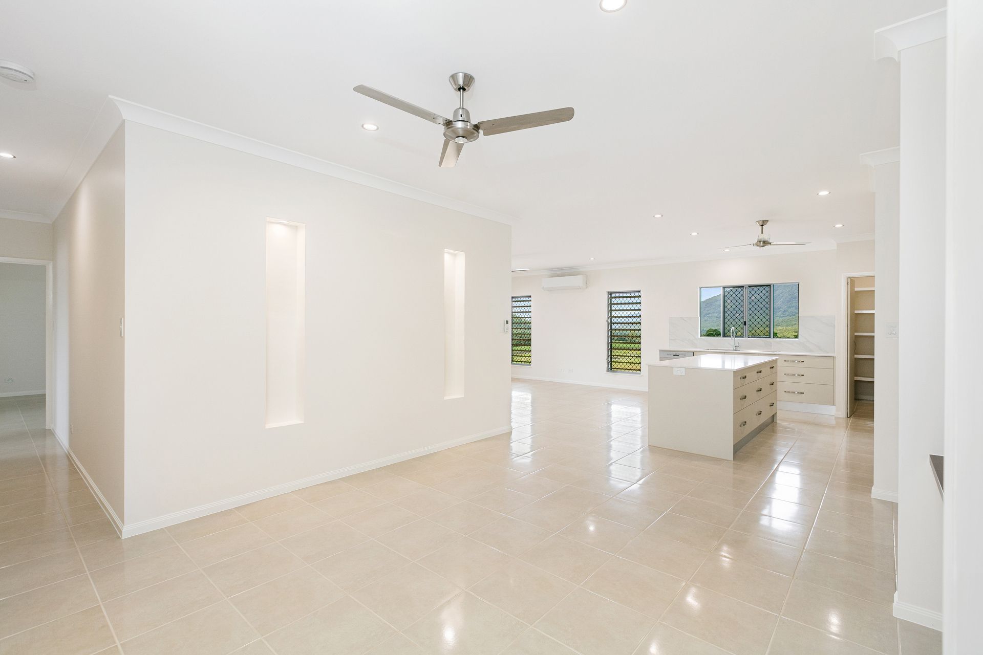 An Open-plan Living and Kitchen Area With Light Tile Floors — Ashlee Jones Homes in Gordonvale, QLD