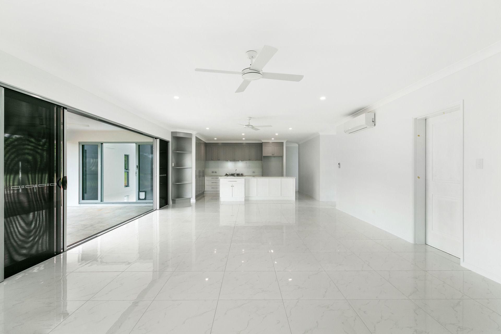 An Open-plan Living Room With White Tiled Floors — Ashlee Jones Homes in Gordonvale, QLD