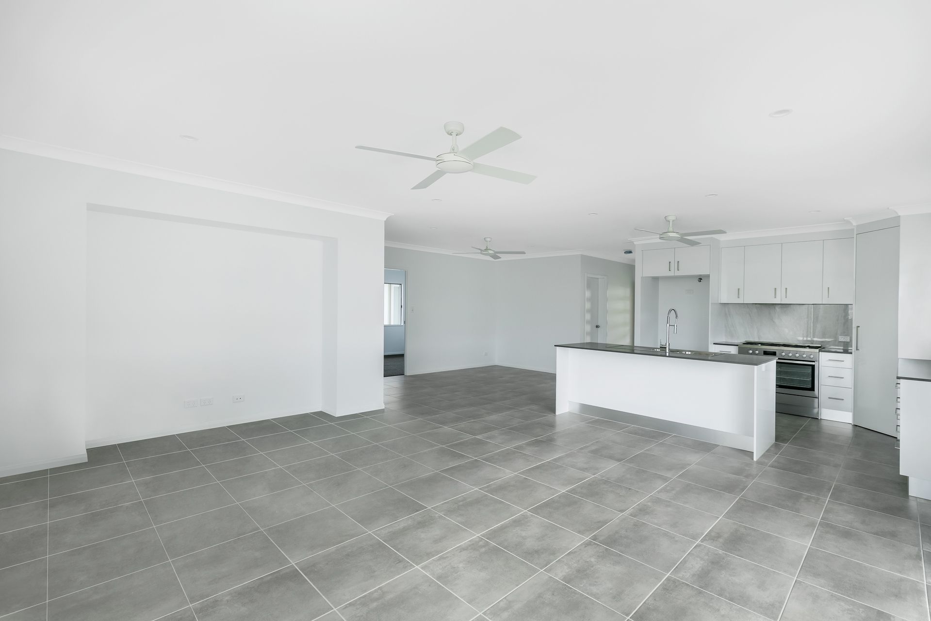 Spacious Open-plan Living and Kitchen Area With White Walls — Ashlee Jones Homes in Gordonvale, QLD