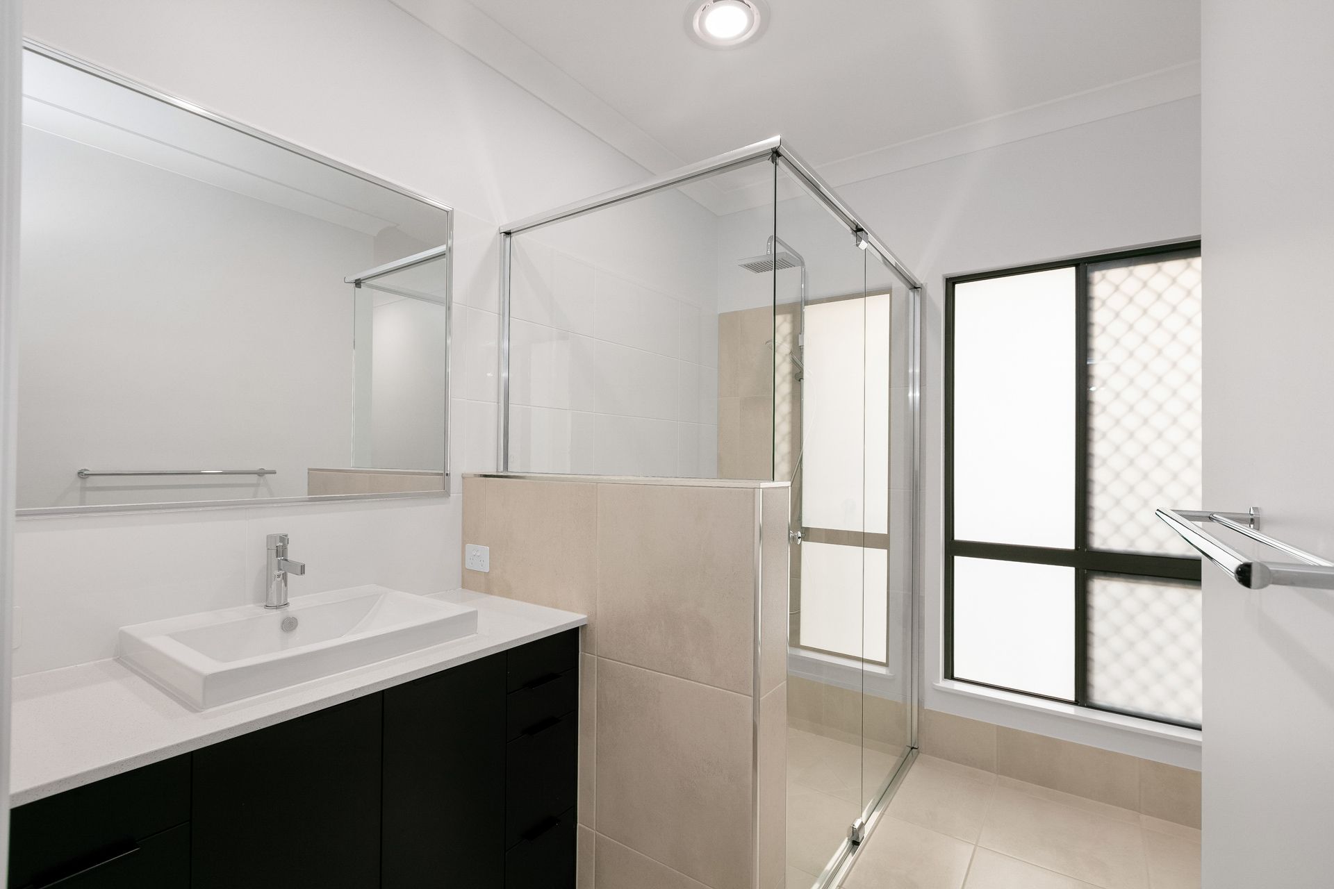 Modern Bathroom Featuring a Black Vanity With a White Sink — Ashlee Jones Homes in Gordonvale, QLD