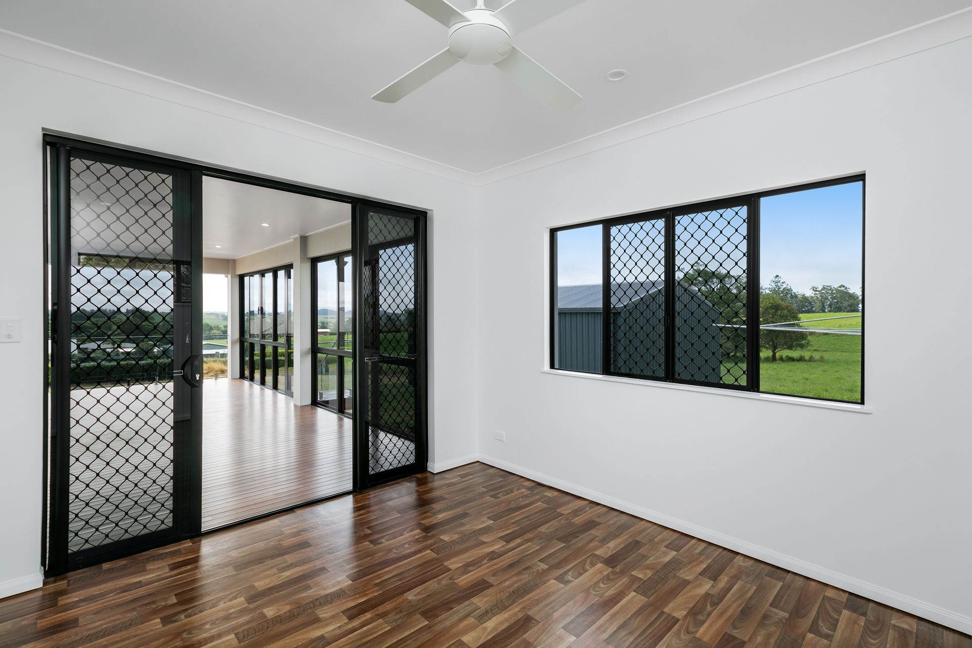 An Empty Room With White Walls, Dark Wood Floors — Ashlee Jones Homes in Gordonvale, QLD
