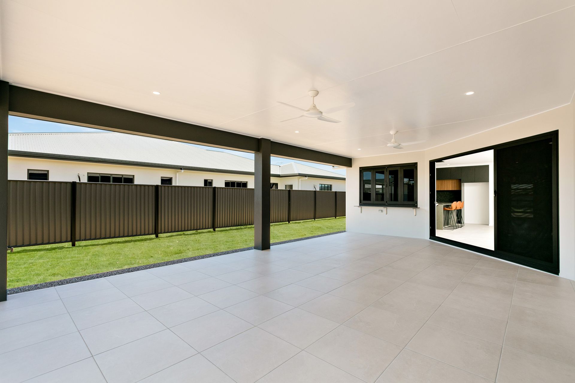 A Spacious, Tiled Outdoor Covered Patio With White Ceilings — Ashlee Jones Homes in Gordonvale, QLD