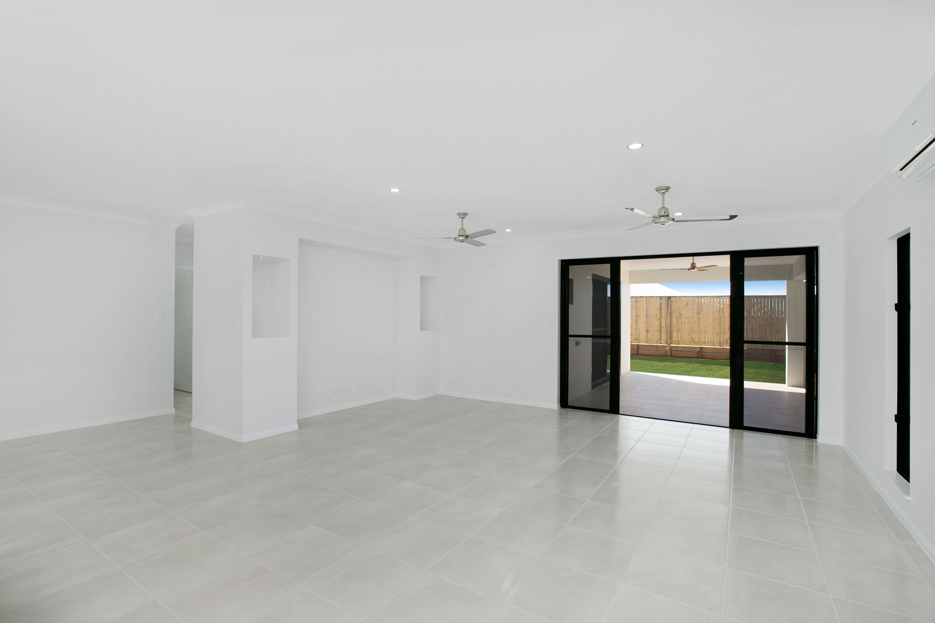 An Empty, Bright Room With White Walls, Light Tile Flooring — Ashlee Jones Homes in Gordonvale, QLD