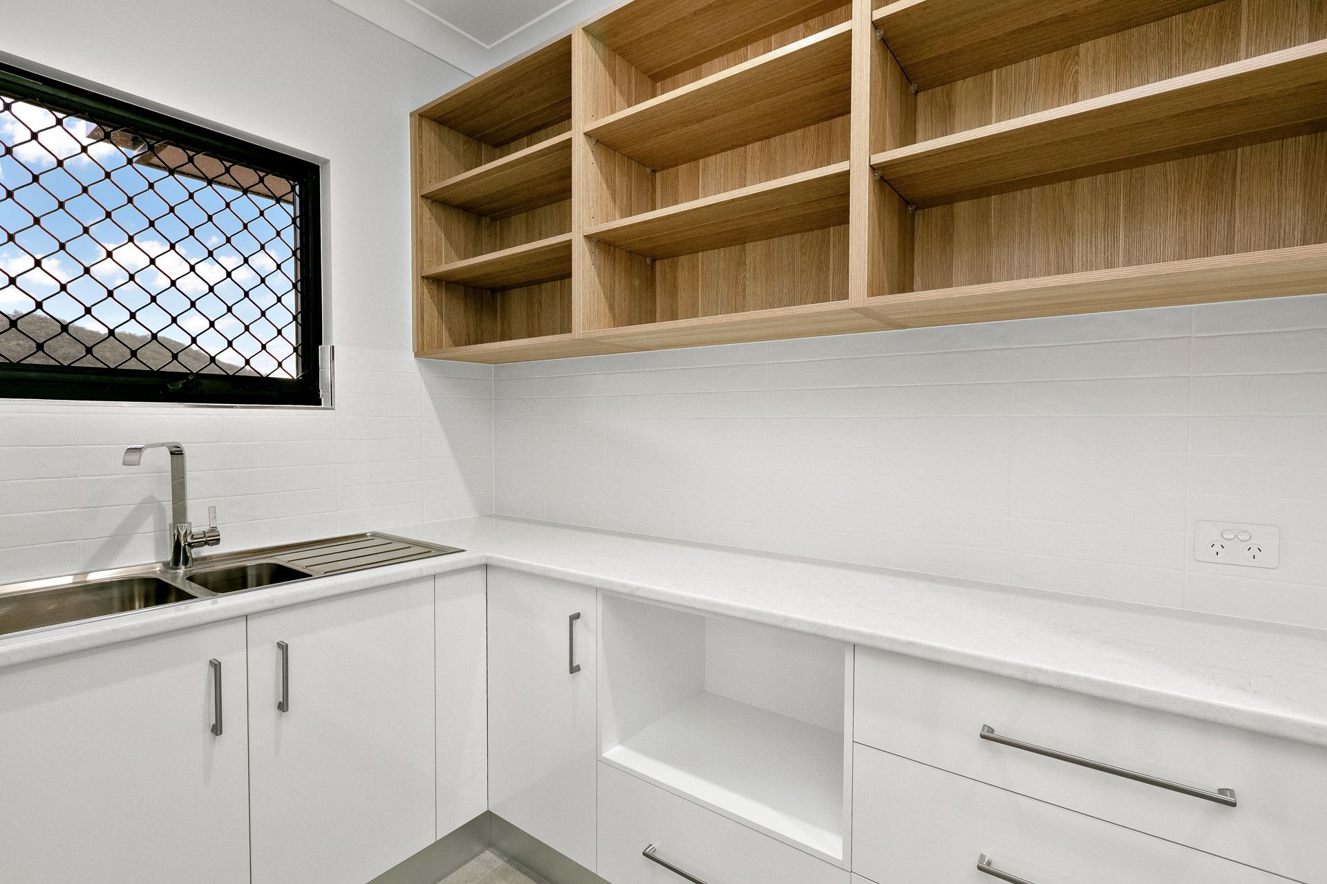 Modern Laundry Room With White Cabinets, Light Wood Open Shelves — Ashlee Jones Homes in Gordonvale, QLD