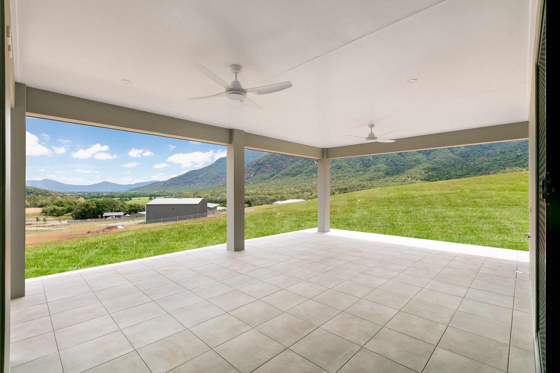A Modern, Covered Patio With Light Grey Tile Flooring — Ashlee Jones Homes in Gordonvale, QLD