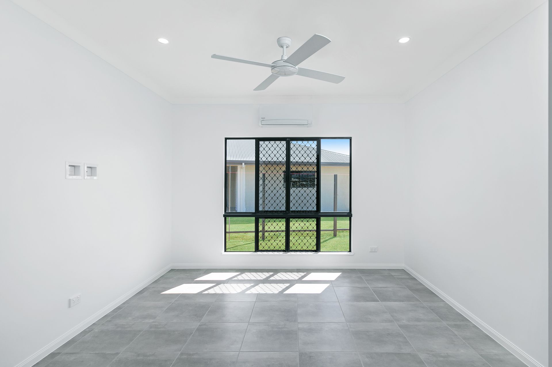 An Empty Room With White Walls, Gray Tiled Floors — Ashlee Jones Homes in Gordonvale, QLD