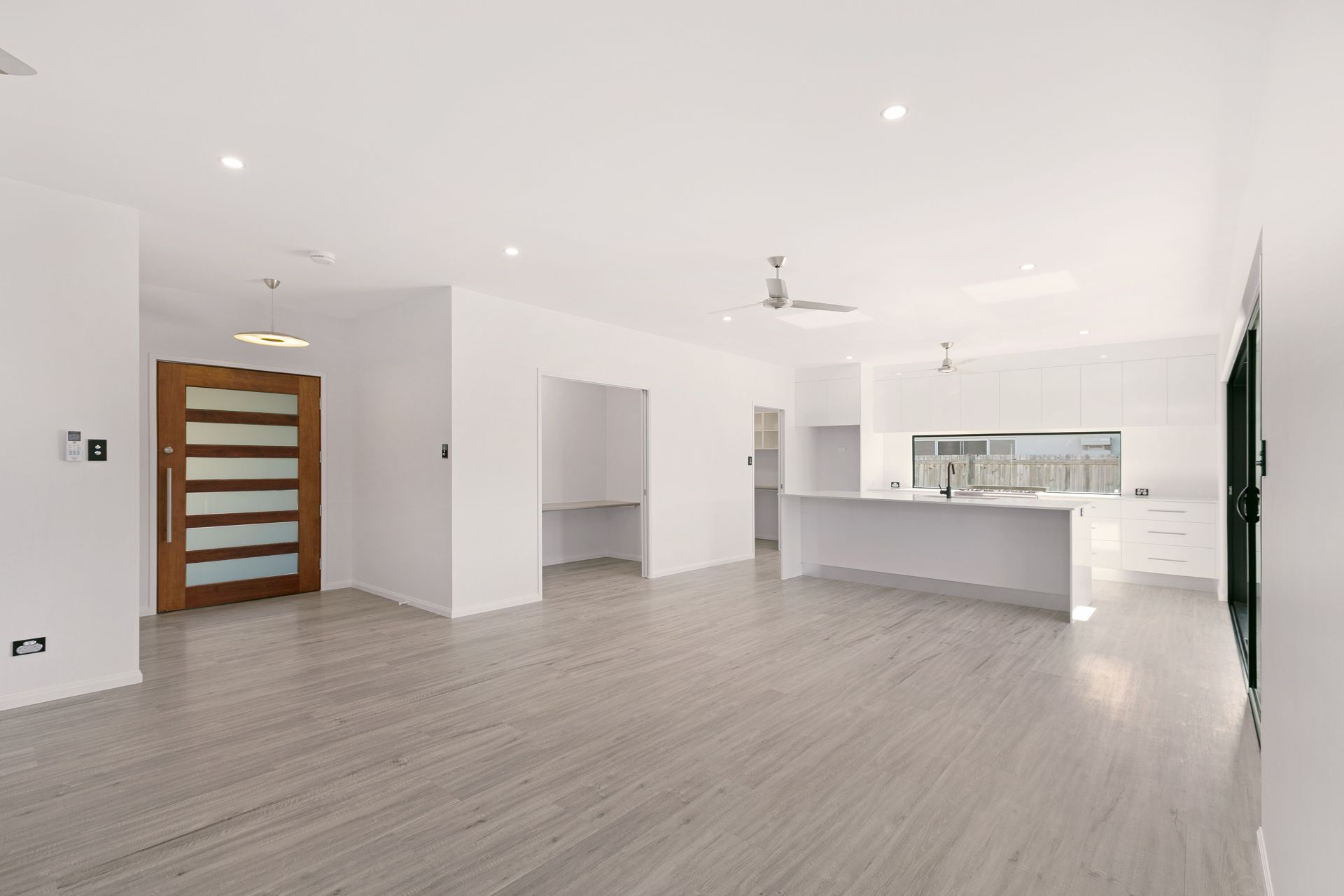 An Open-plan, Minimalist Room With Wood-look Flooring — Ashlee Jones Homes in Gordonvale, QLD