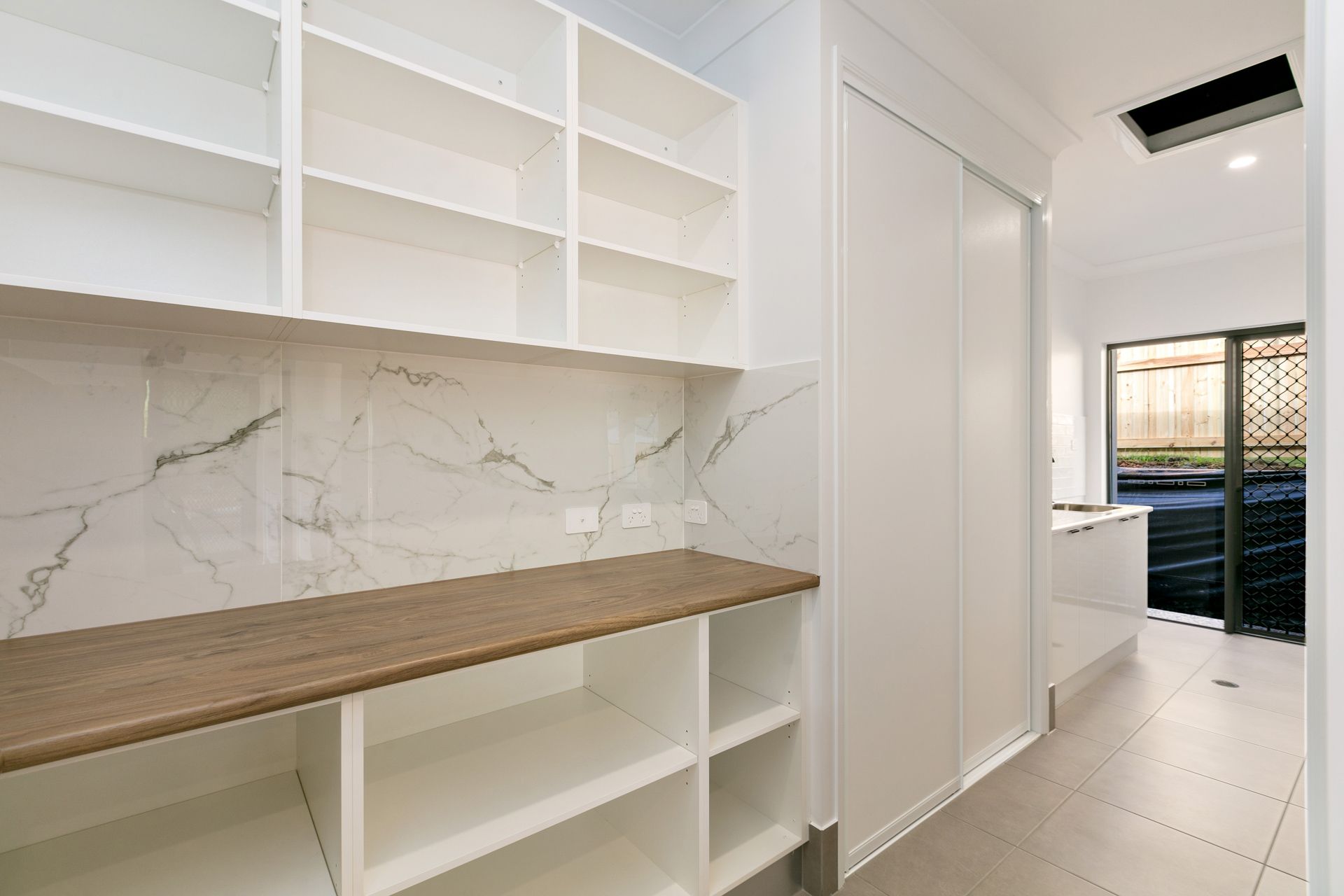 A Modern Pantry With Open Shelving, a Wooden Countertop — Ashlee Jones Homes in Gordonvale, QLD