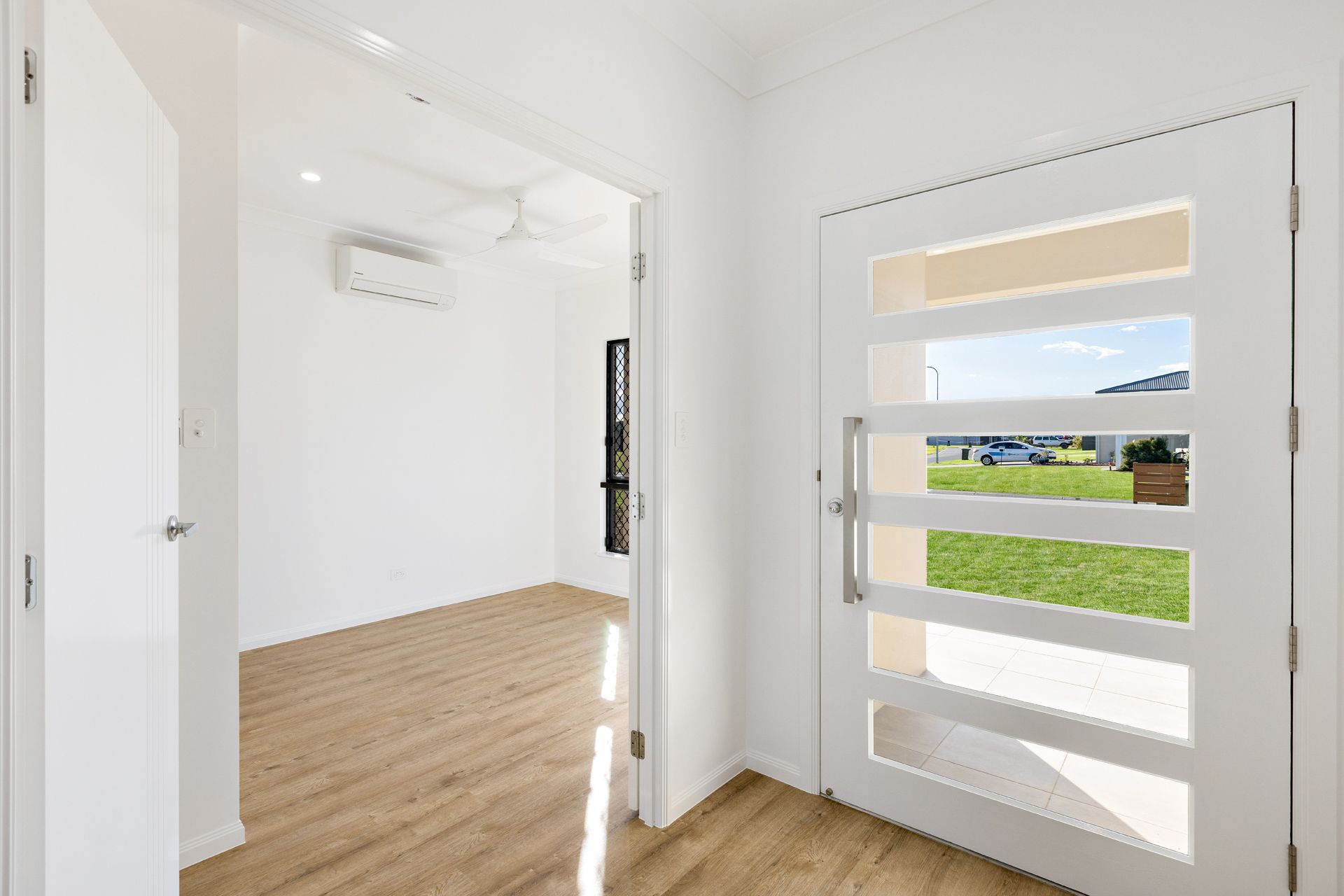 A Brightly Lit, Minimalist Entryway Featuring White Walls — Ashlee Jones Homes in Gordonvale, QLD