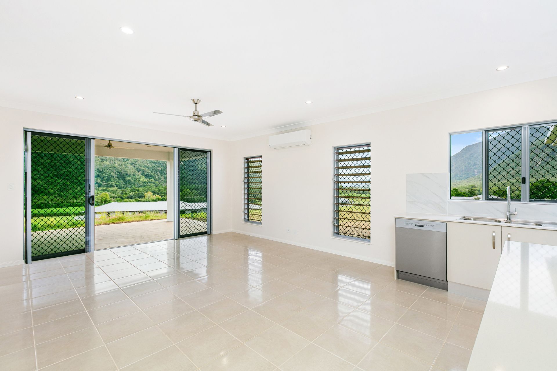 A Bright, Modern Room With White Walls, Tiled Floors — Ashlee Jones Homes in Gordonvale, QLD