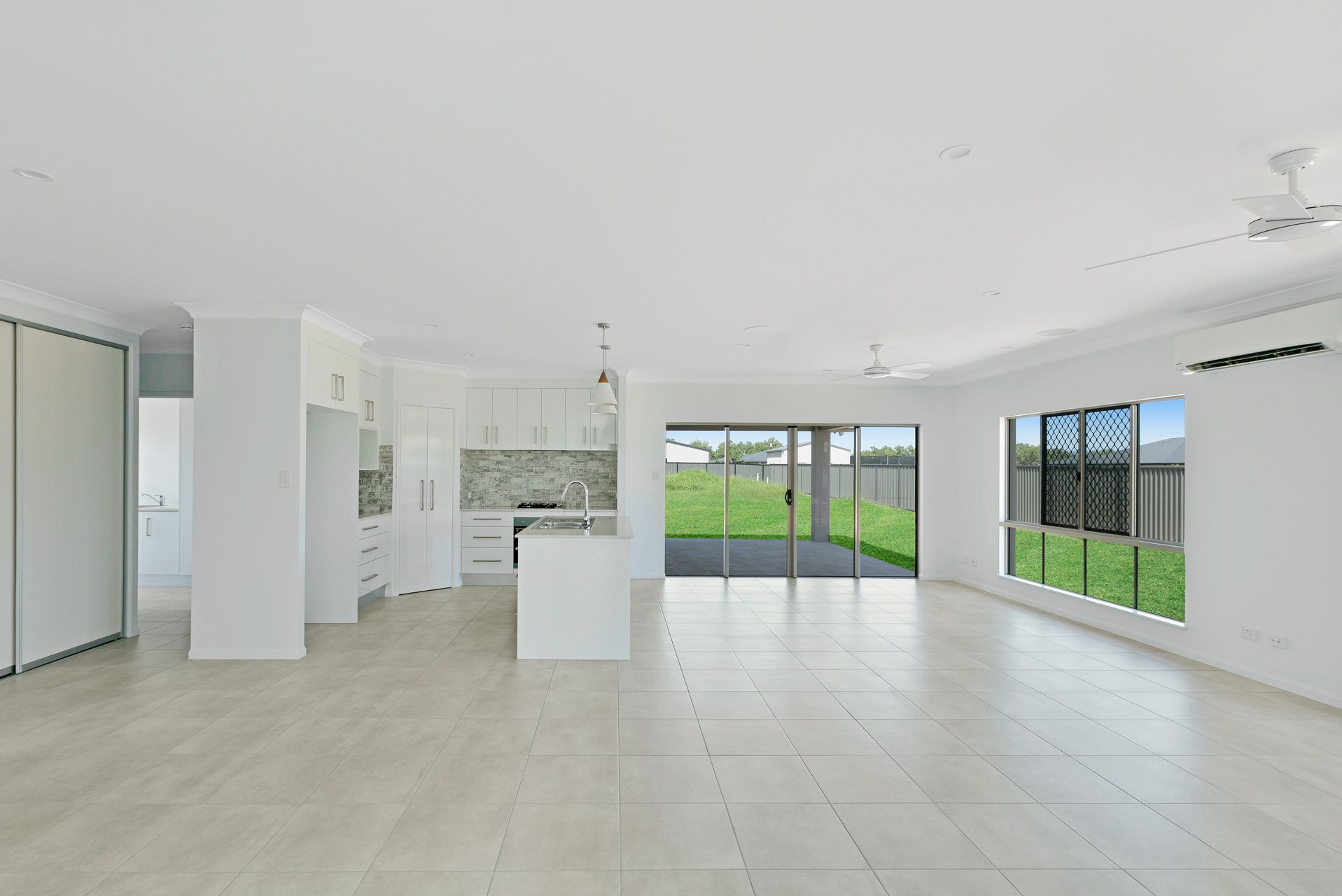 A Bright, Open-plan Interior Featuring a Modern White Kitchen — Ashlee Jones Homes in Gordonvale, QLD