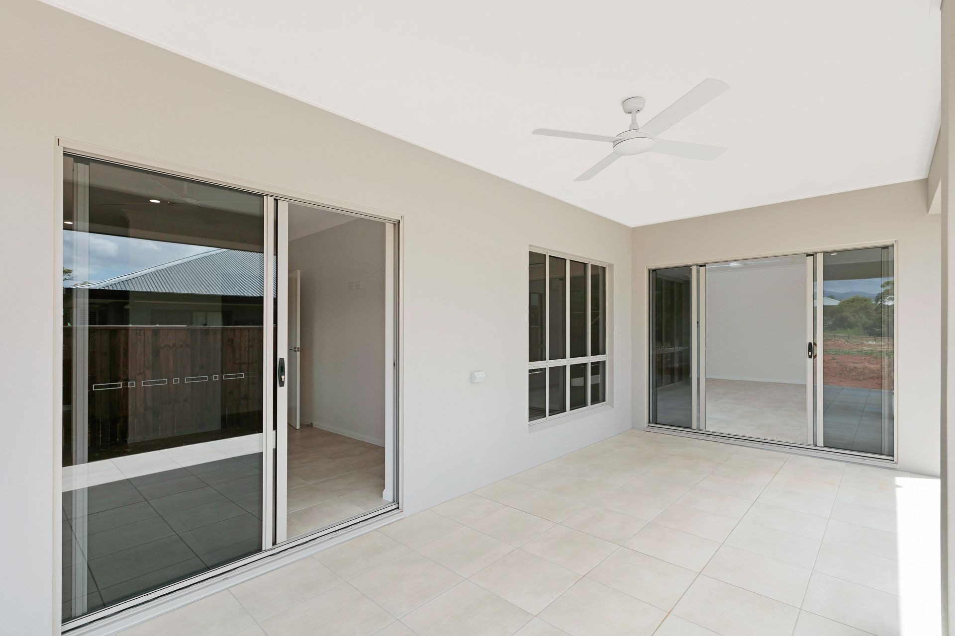 A Covered Outdoor Patio With Light-colored Tile Floors — Ashlee Jones Homes in Gordonvale, QLD