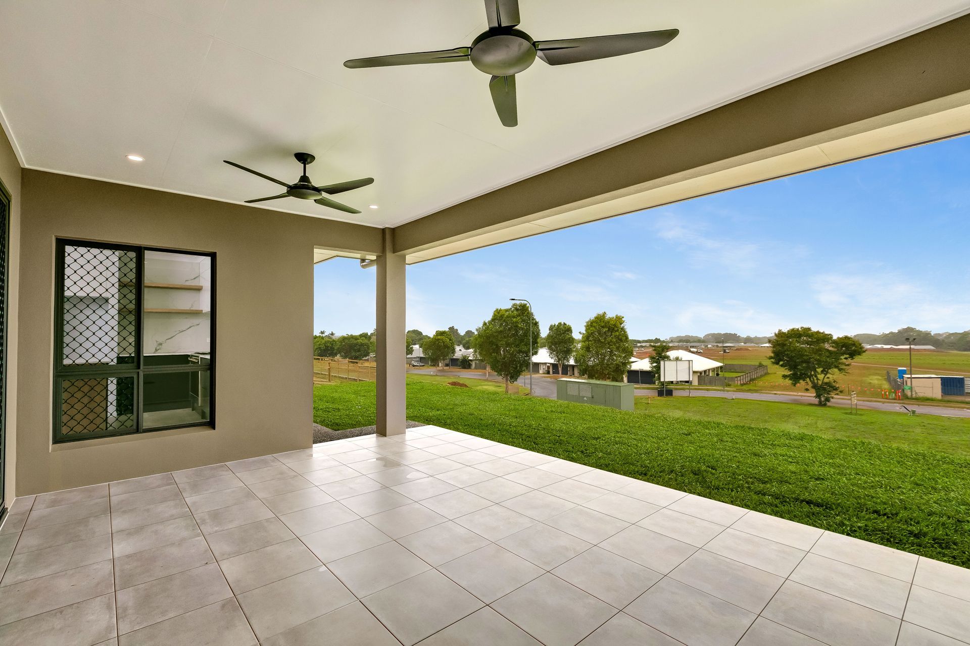 A Covered Outdoor Patio With Light Tiled Flooring — Ashlee Jones Homes in Gordonvale, QLD